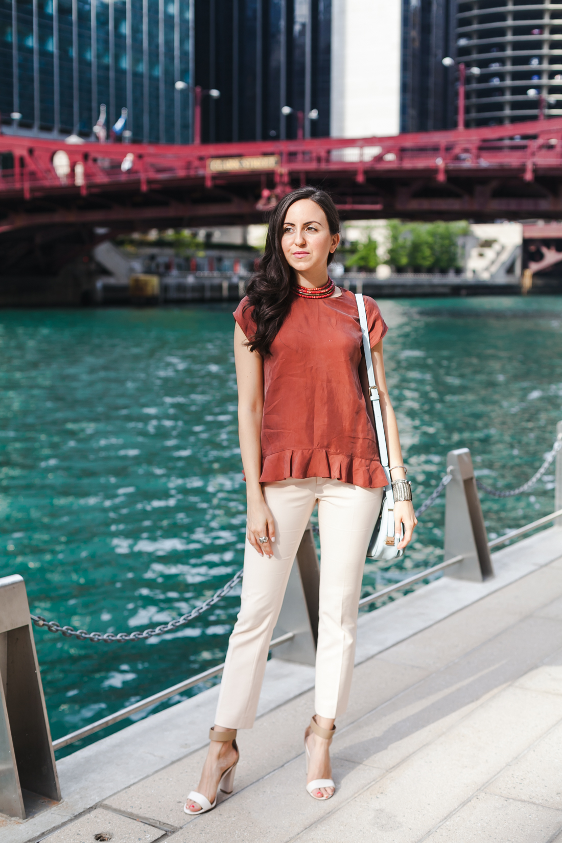 Nomad Luxuries Yana Puaca wearing a rust ruffled top and pink pants in chicago summer