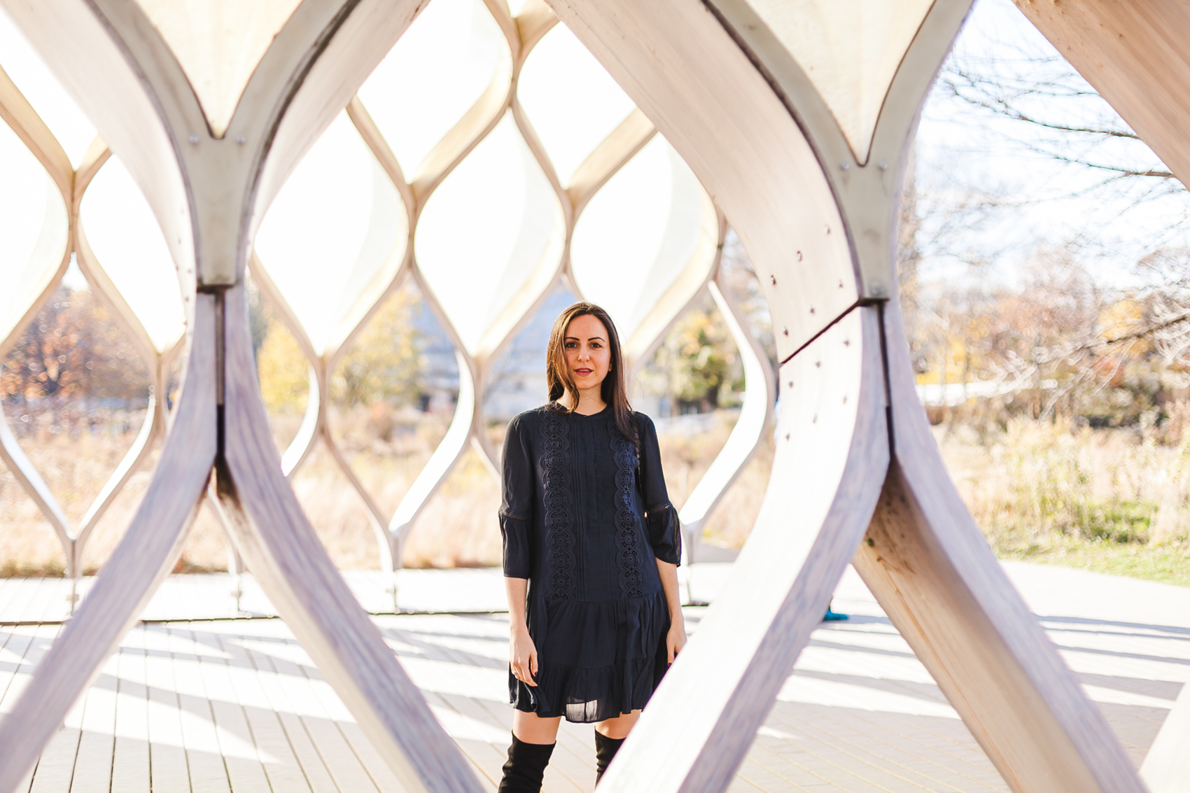 Yana Frigelis of NoMad Luxuries wearing a navy boho inspired dress from loft and over the knee boots for fall in chicago