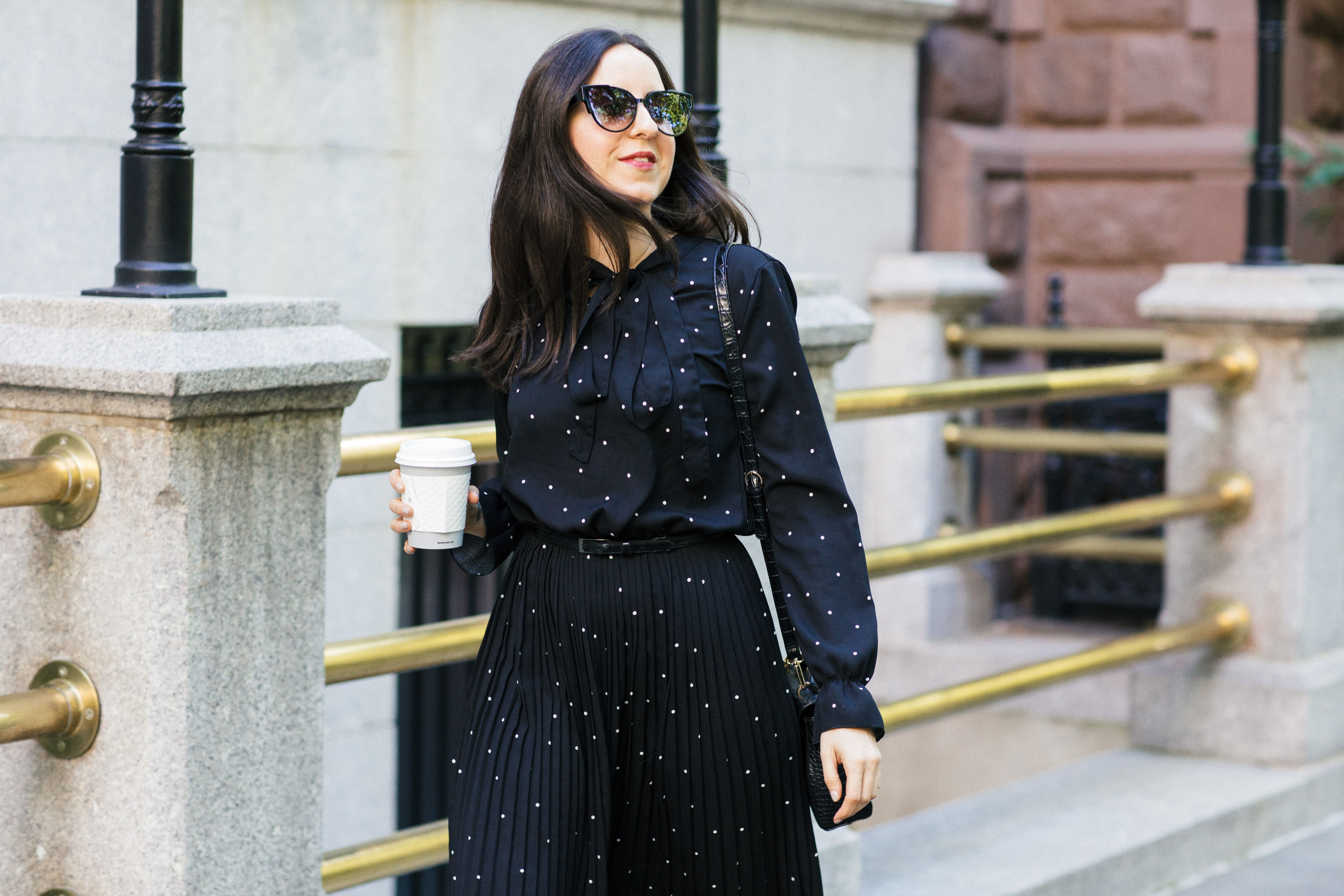 Yana Frigelis of NoMad Luxuries wearing a black polka dot dress from Romwe for the fall in Gramercy Park New York