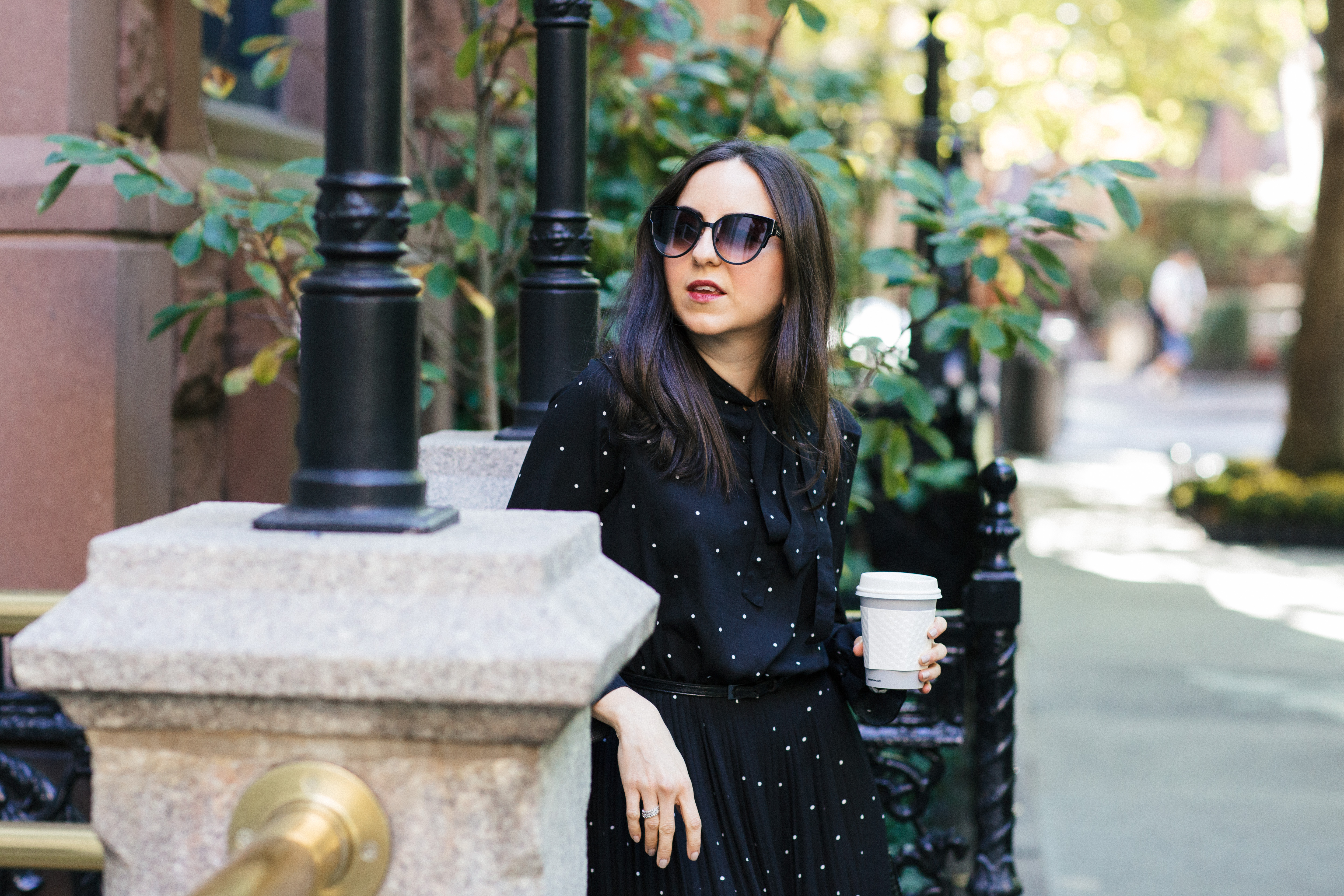 Yana Frigelis of NoMad Luxuries wearing a black polka dot dress from Romwe for the fall in Gramercy Park New York
