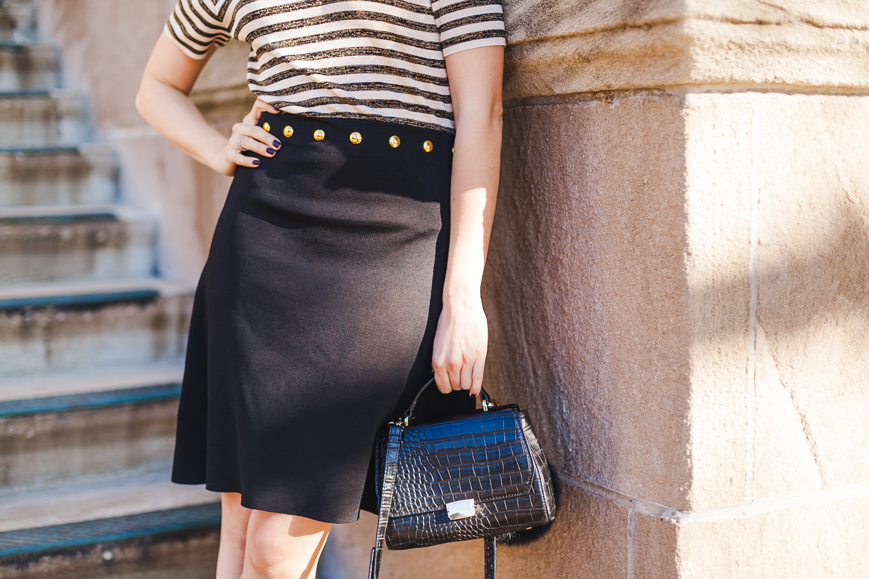 Yana Frigelis of NoMad Luxuries wearing a Sandro striped dress in black and gold in Chicago