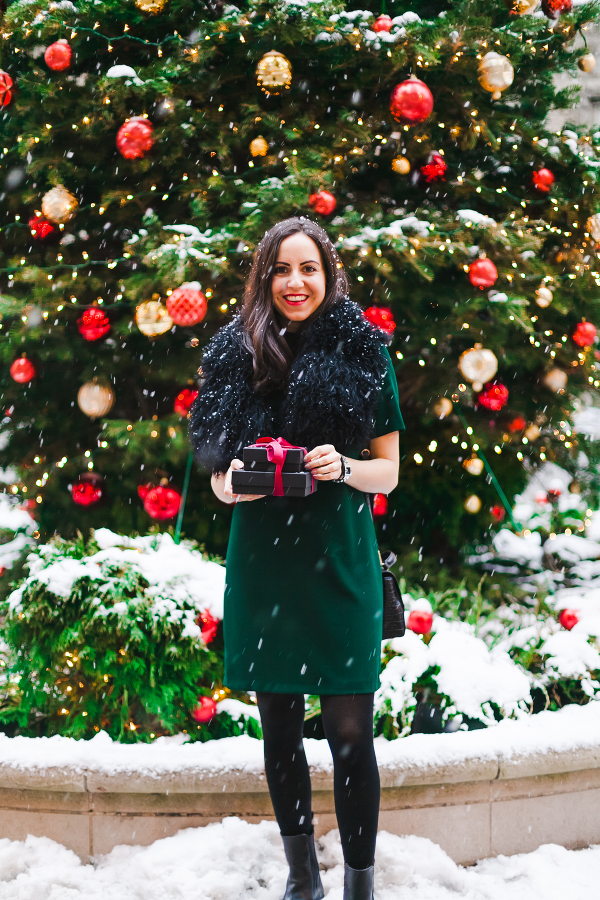 Yana Frigelis of NoMad Luxuries wears a green cocktail dress from zara and a fur scarf from asos for the holidays 