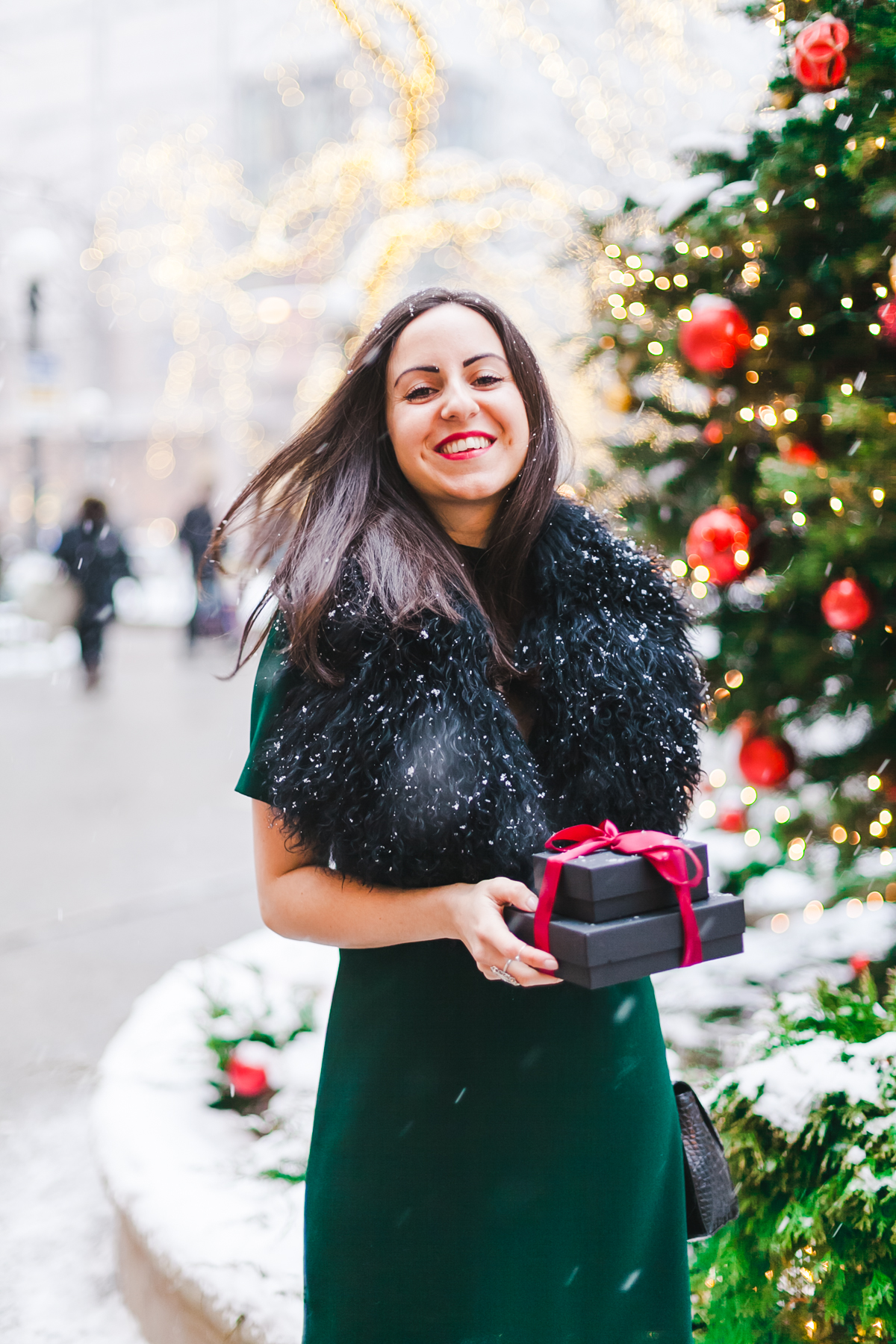 Yana Frigelis of NoMad Luxuries wears a green cocktail dress from zara and a fur scarf from asos for the holidays 