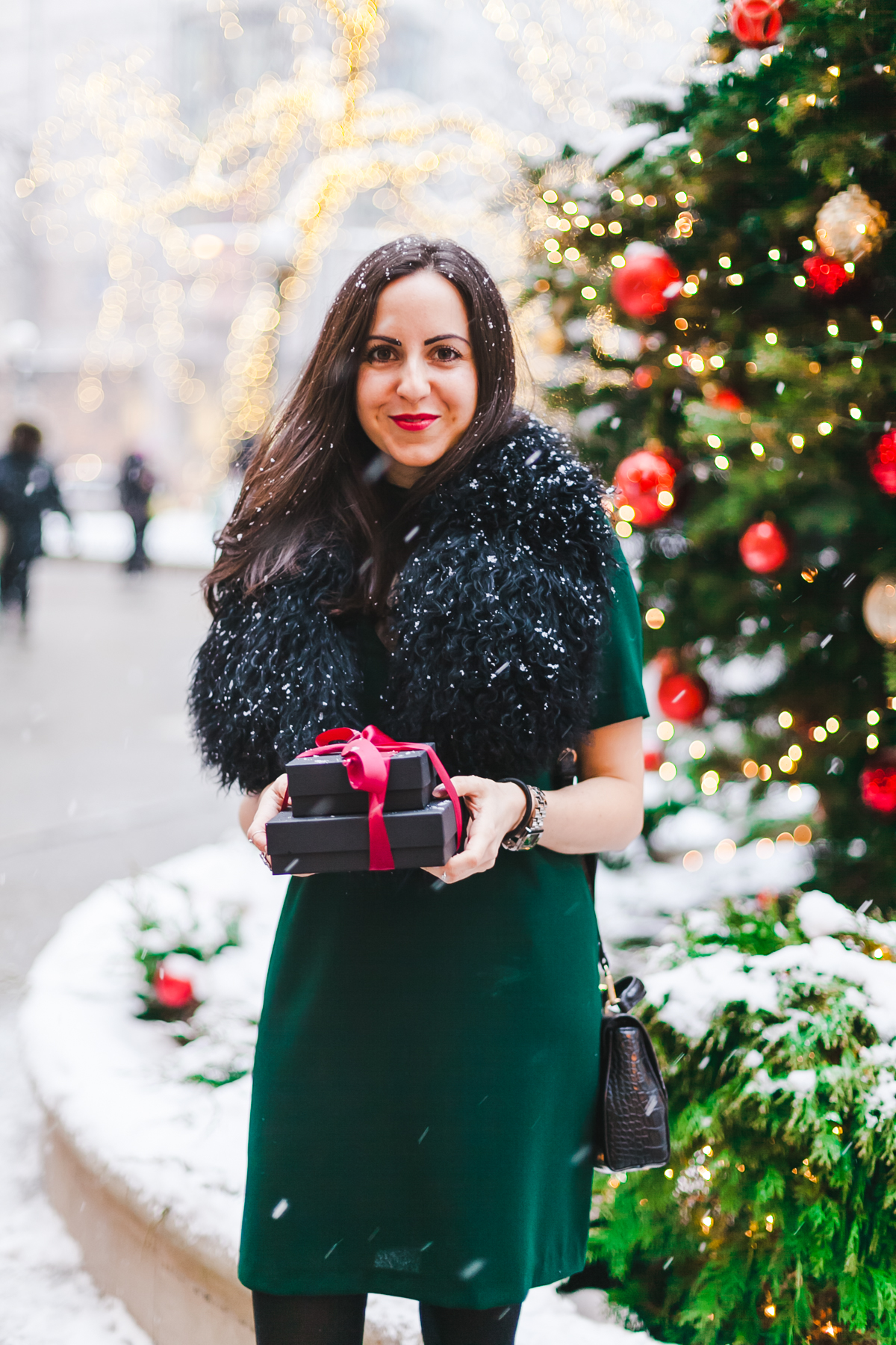 Yana Frigelis of NoMad Luxuries wears a green cocktail dress from zara and a fur scarf from asos for the holidays 