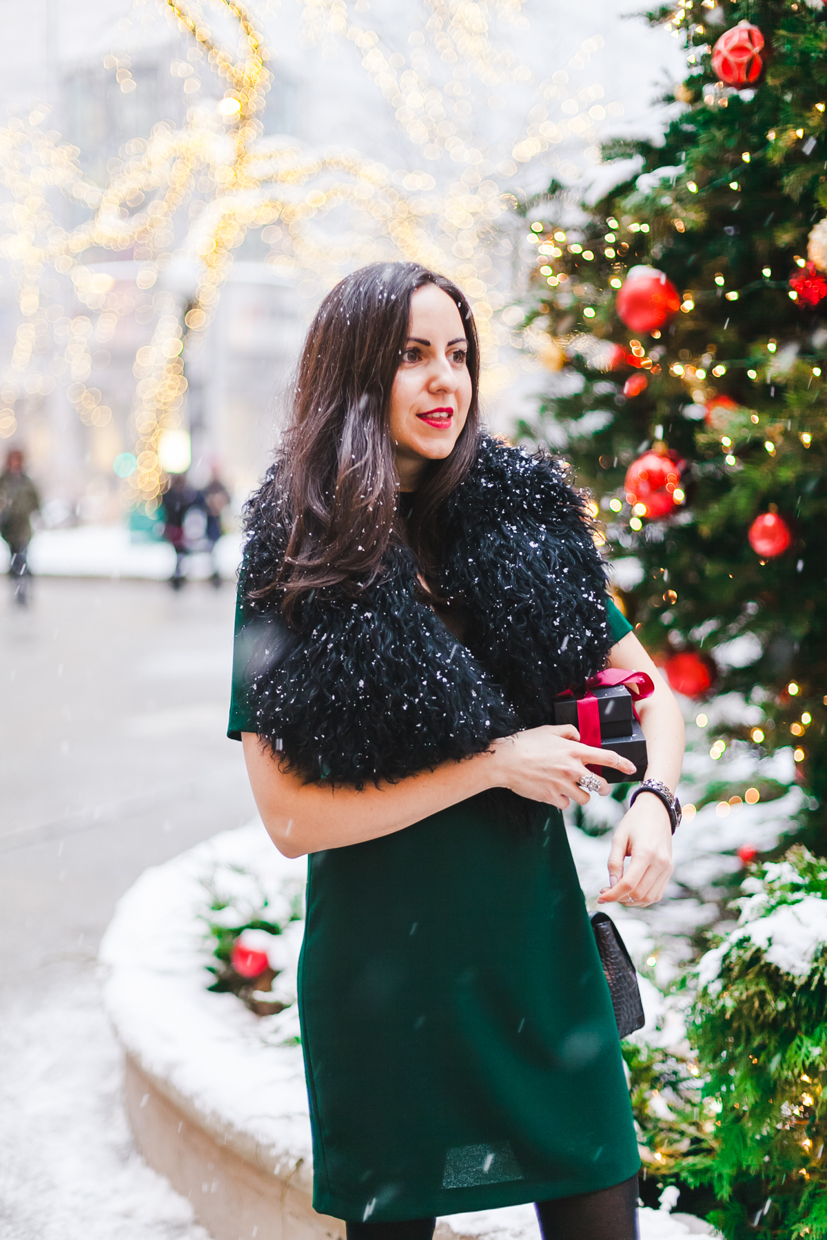 Yana Frigelis of NoMad Luxuries wears a green cocktail dress from zara and a fur scarf from asos for the holidays 