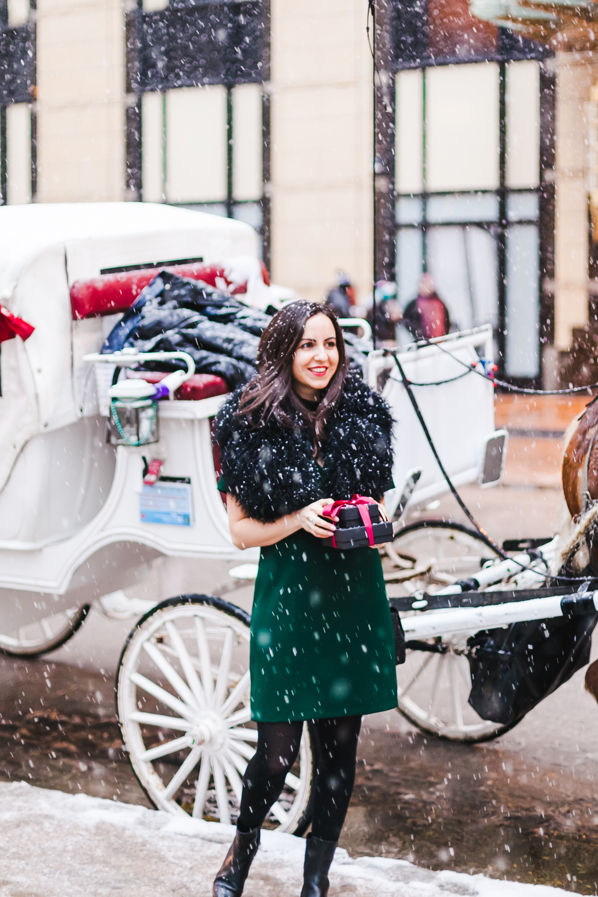 Yana Frigelis of NoMad Luxuries wears a green cocktail dress from zara and a fur scarf from asos for the holidays 