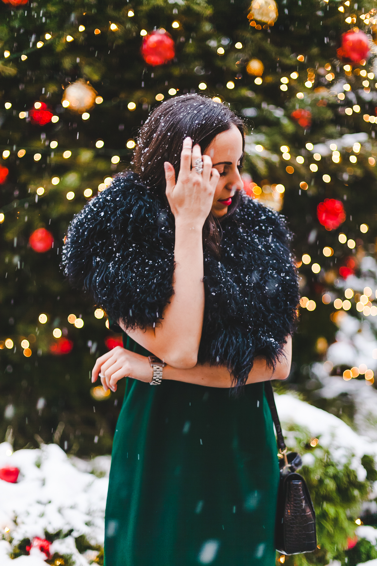 Yana Frigelis of NoMad Luxuries wears a green cocktail dress from zara and a fur scarf from asos for the holidays 