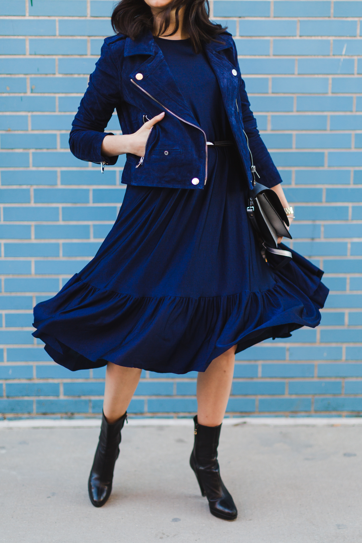 Yana Frigelis of NoMad Luxuries wearing a navy zara pleated dress with a navy moto jacket from tj maxx for spring