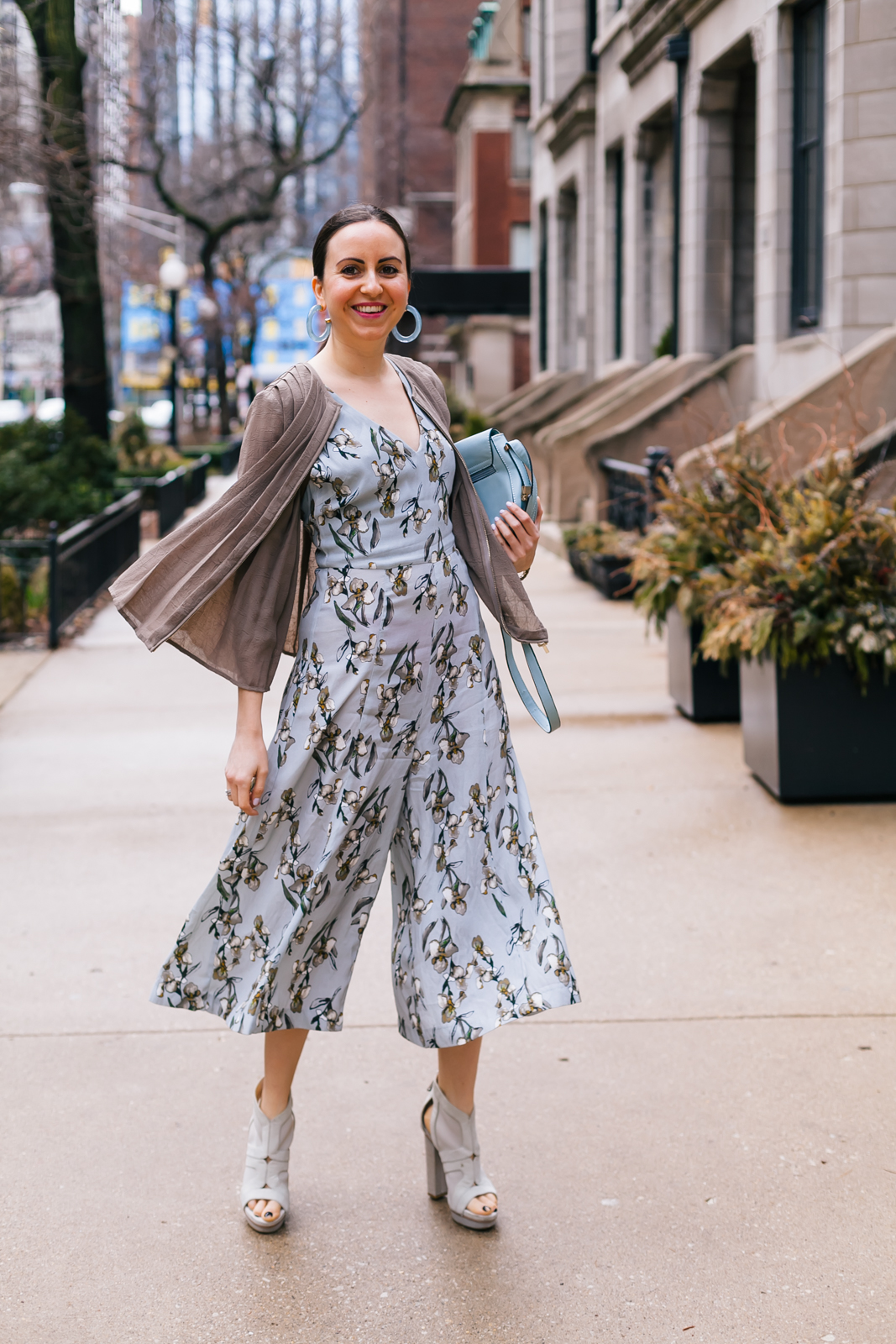 Yana Frigelis of NoMad Luxuries wearing a floral culotte jumpsuit in nuetral colors and accessories for Spring