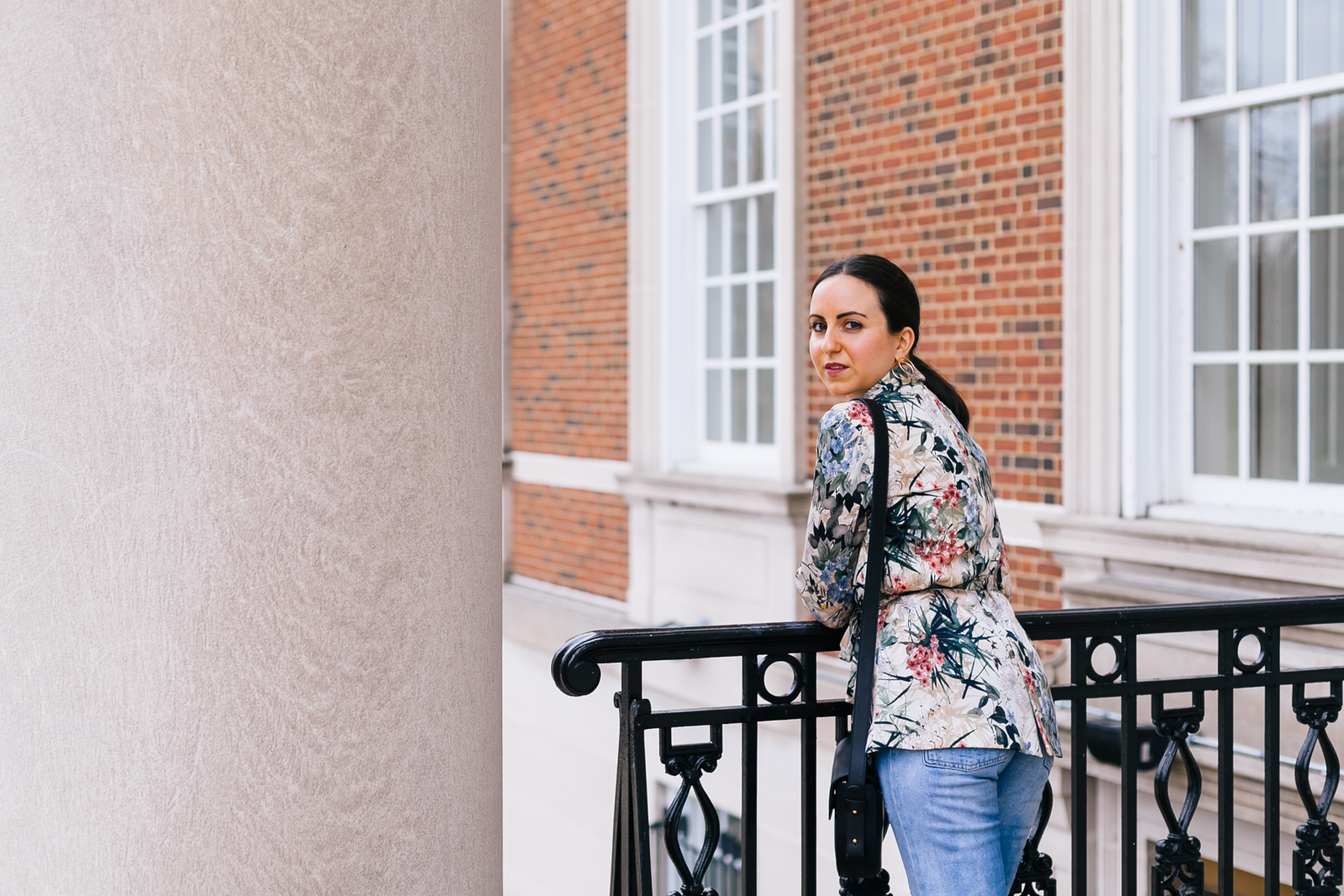 Yana Frigelis of NoMad Luxuries wearing a floral blazer from Zara with boyfriends jeans and black accessories for Spring 