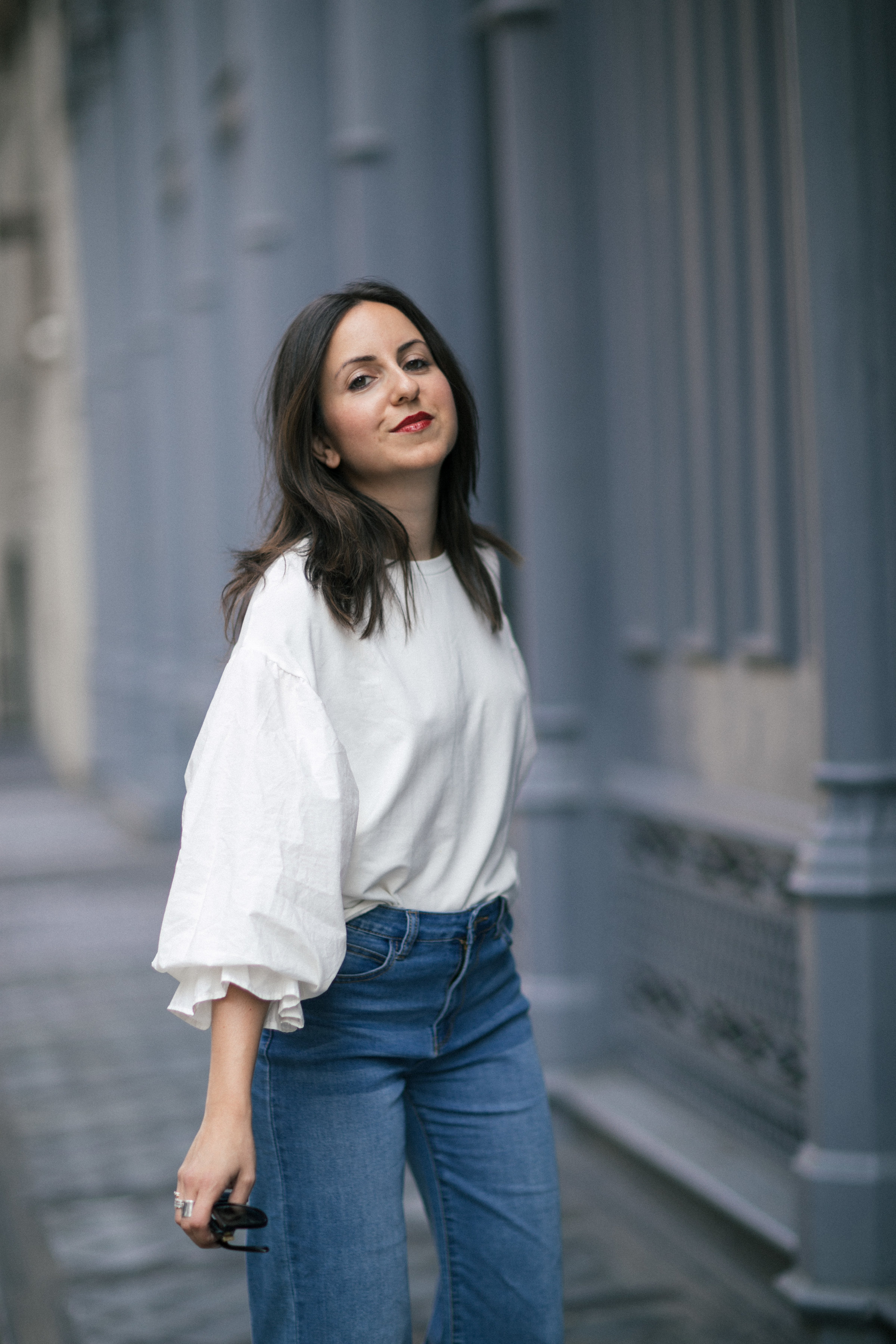 Yana Frigelis of NoMad Luxuries showing how to style a casual denim look with a sweatshirt with statement sleeves from mango and velvet, bow mules for Fall 