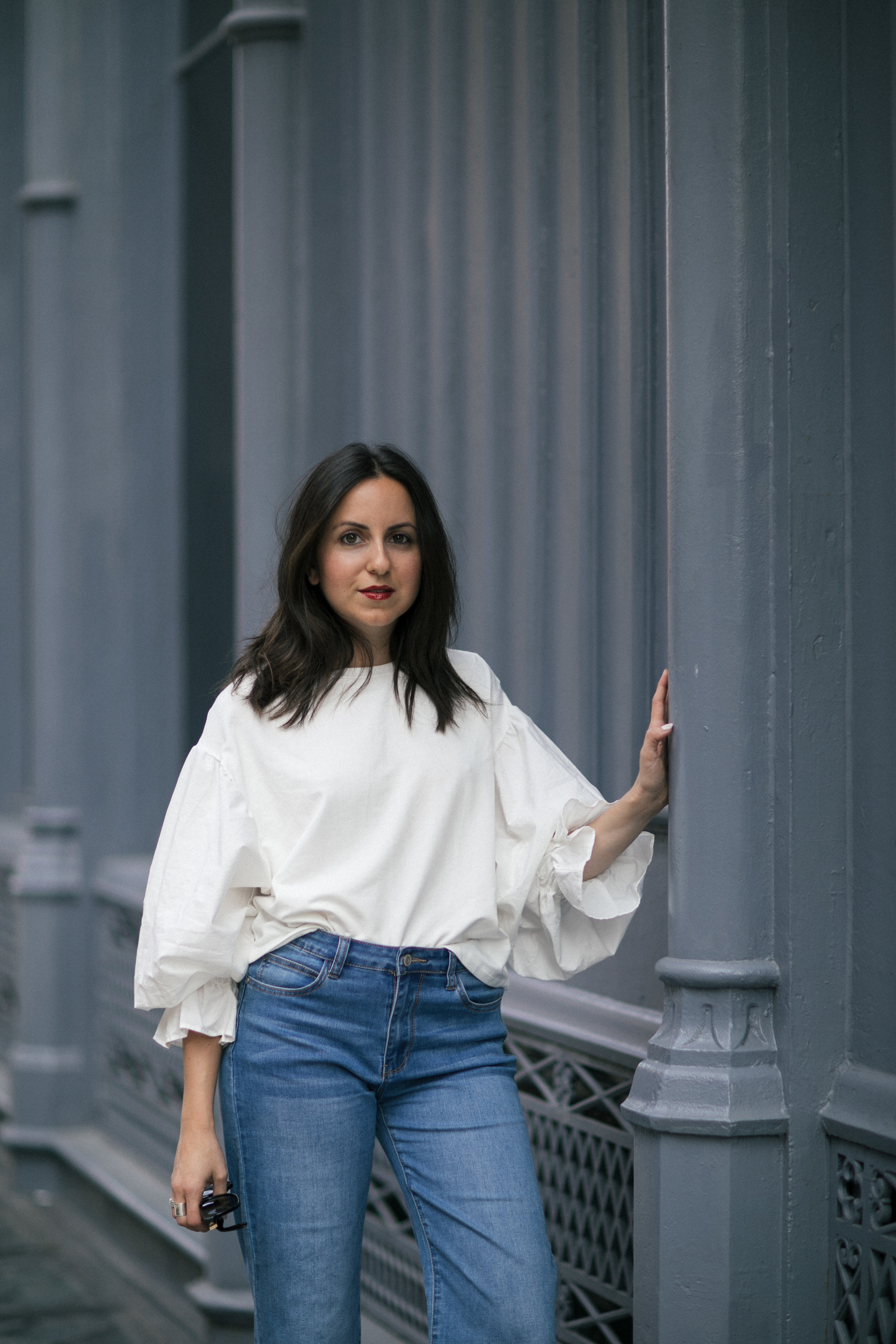 Yana Frigelis of NoMad Luxuries showing how to style a casual denim look with a sweatshirt with statement sleeves from mango and velvet, bow mules for Fall 