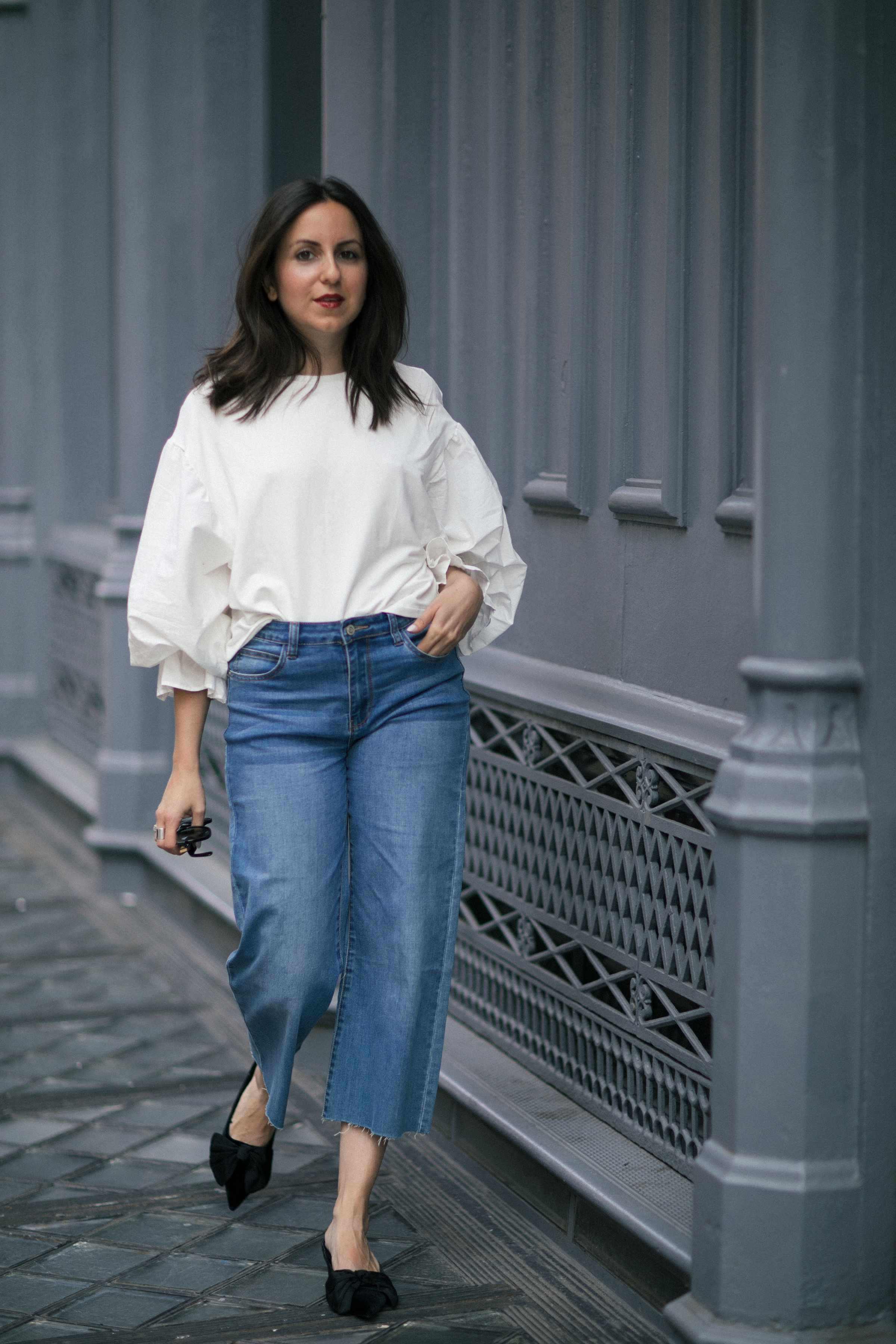 Yana Frigelis of NoMad Luxuries showing how to style a casual denim look with a sweatshirt with statement sleeves from mango and velvet, bow mules for Fall 