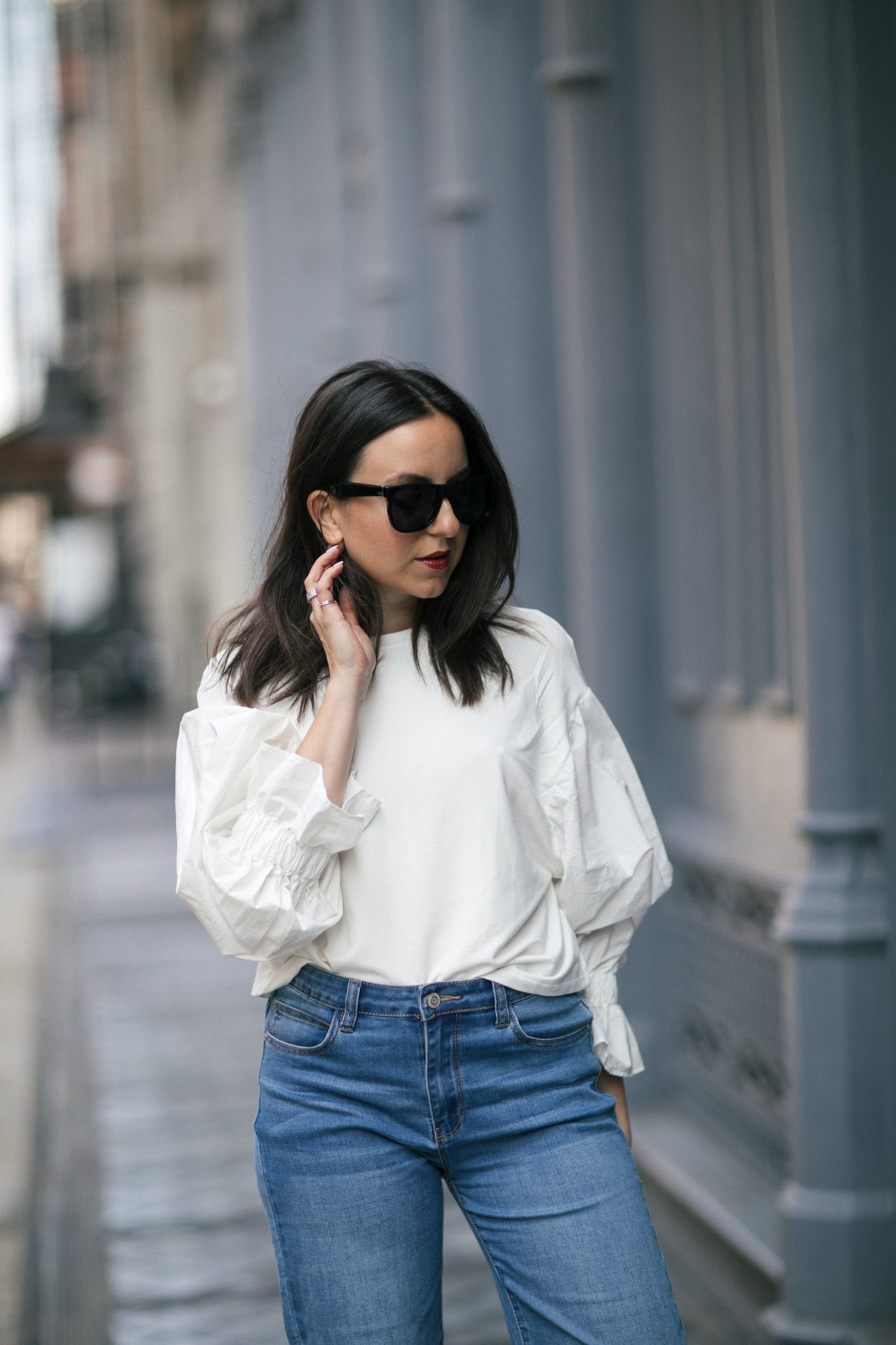 Yana Frigelis of NoMad Luxuries showing how to style a casual denim look with a sweatshirt with statement sleeves from mango and velvet, bow mules for Fall 