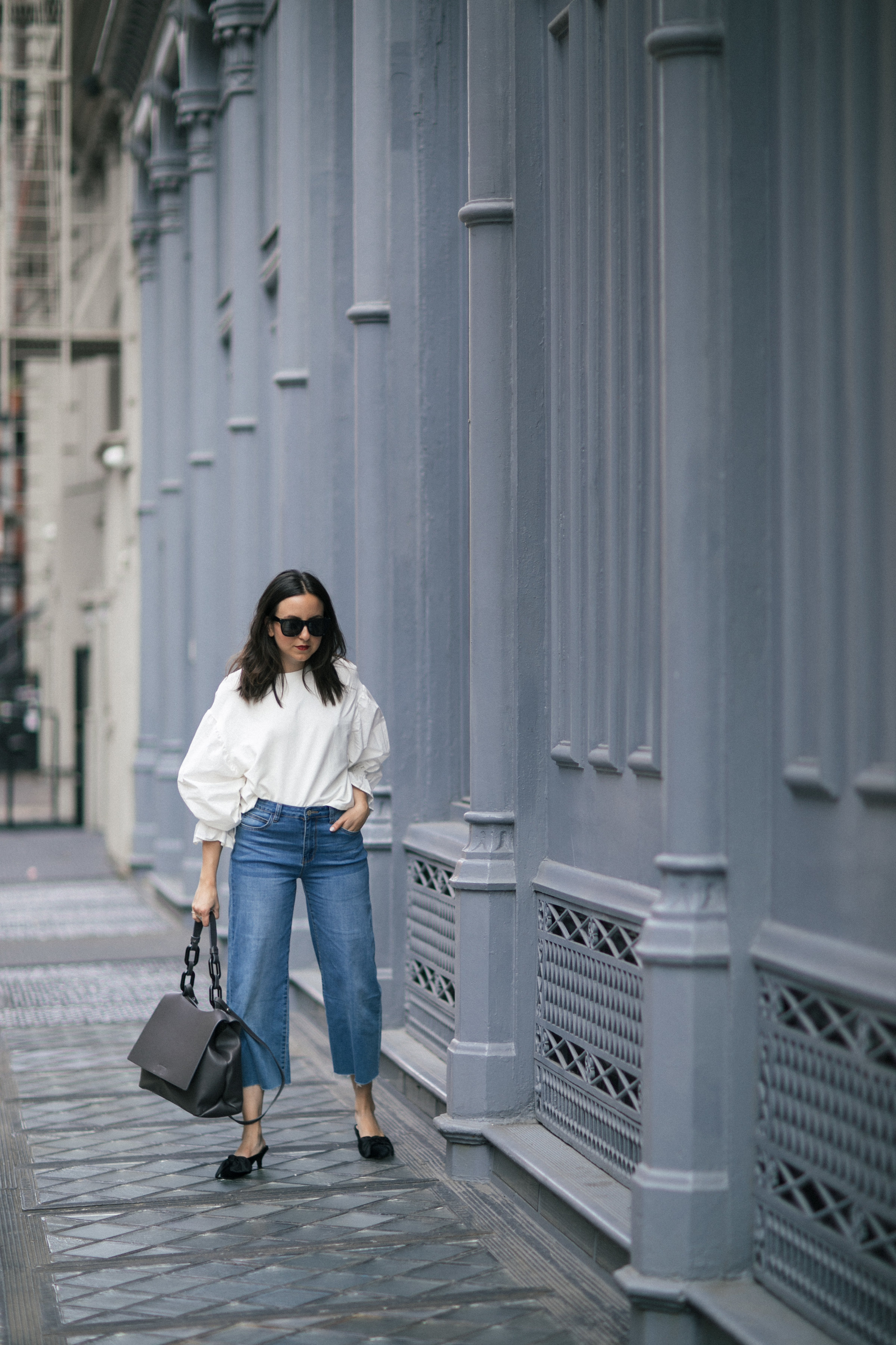 Yana Frigelis of NoMad Luxuries showing how to style a casual denim look with a sweatshirt with statement sleeves from mango and velvet, bow mules for Fall 