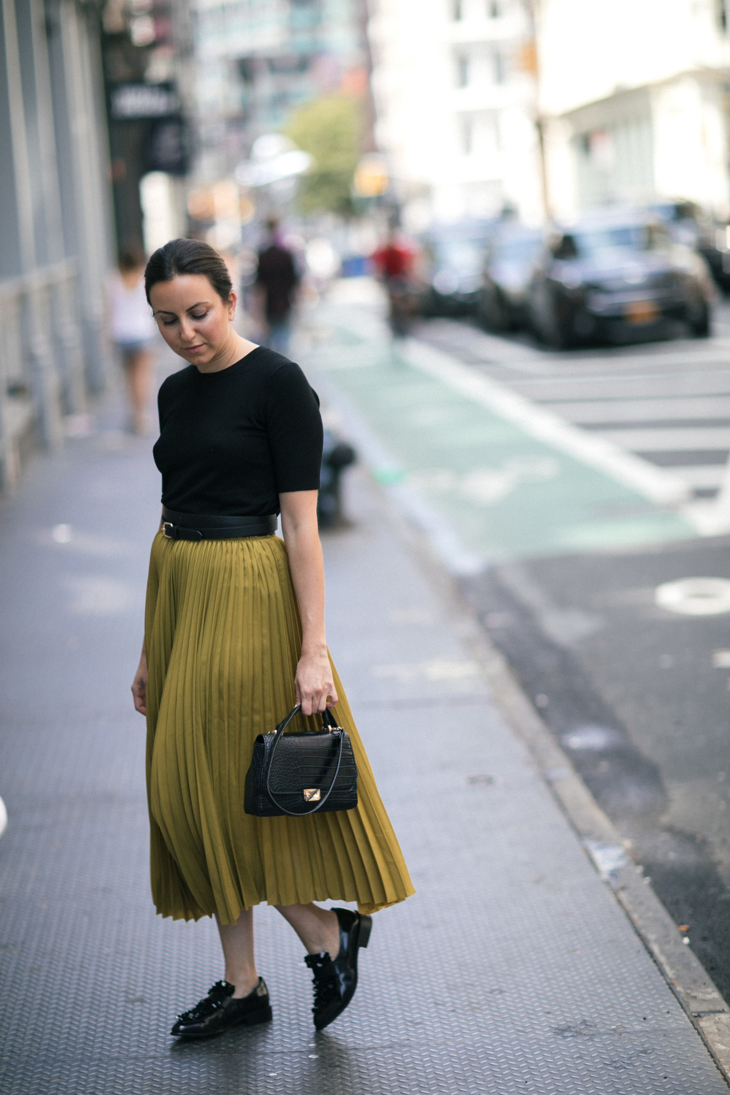 Yana Frigelis of NoMad Luxuries wearing a midi skirt from Zara for a fall trend and loafers for a casual look in new york