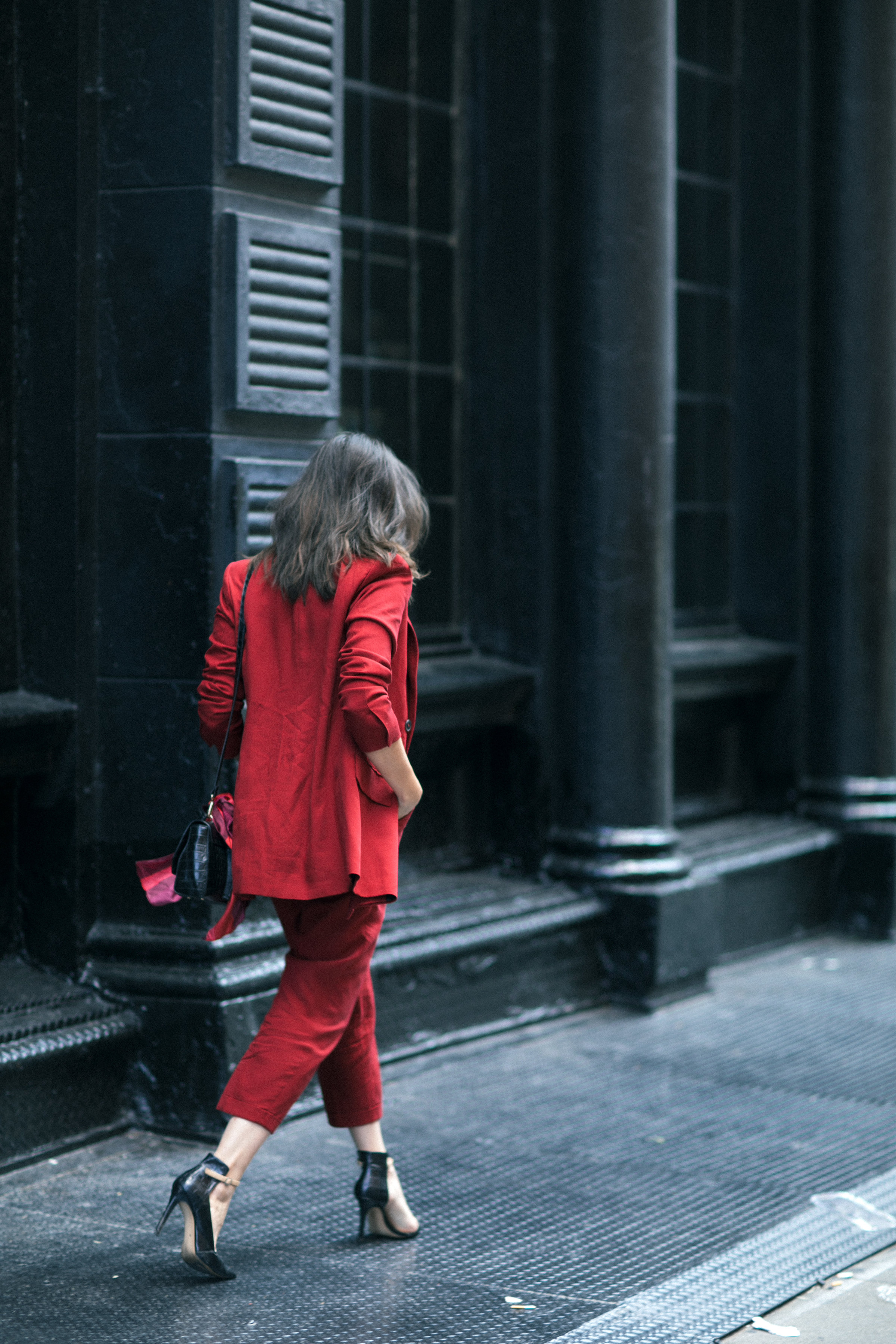 Yana Frigelis of NoMad Luxuries wearing Fall's it color of the season red for new york fashion week in a pant suit from Zara