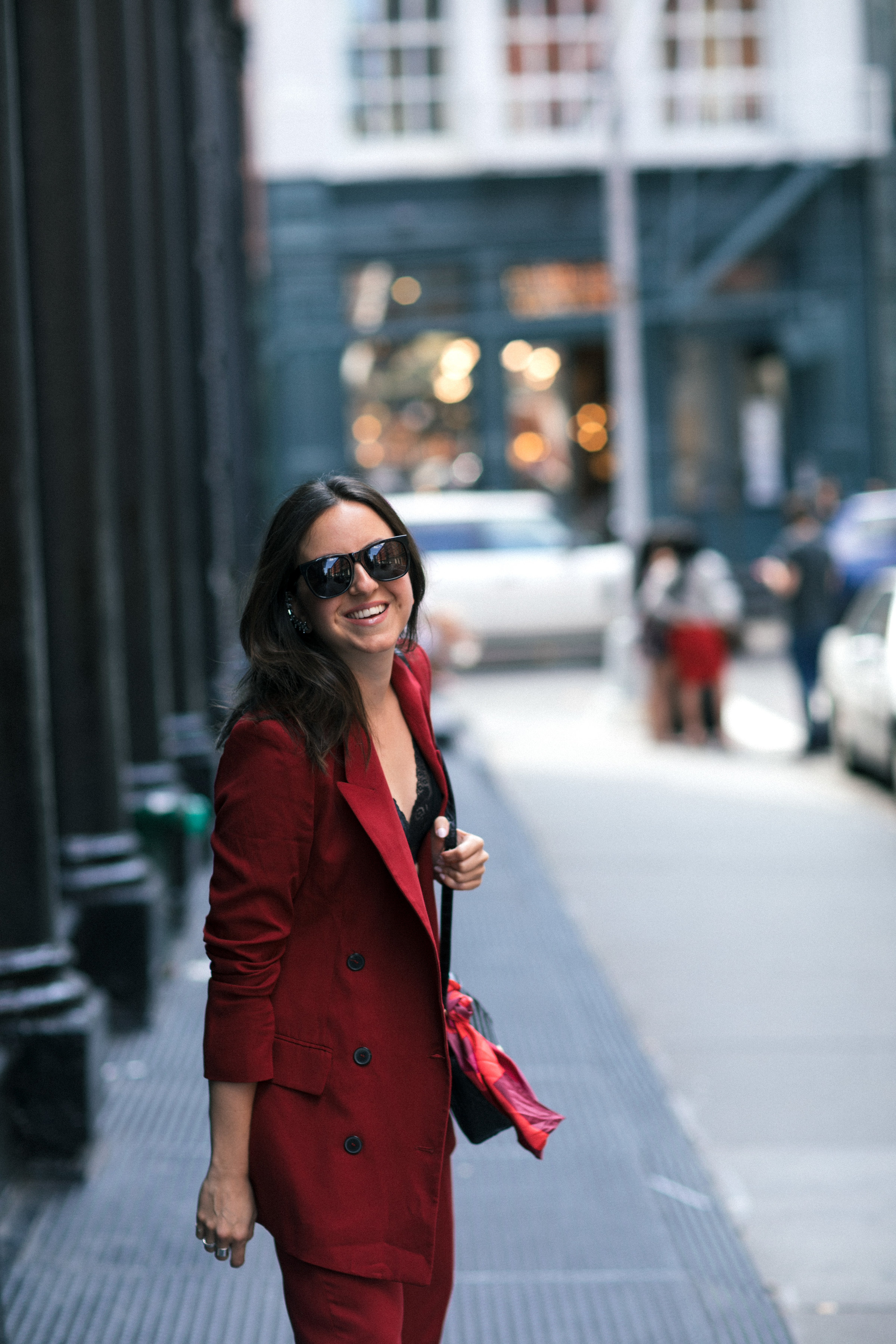 Yana Frigelis of NoMad Luxuries wearing Fall's it color of the season red for new york fashion week in a pant suit from Zara