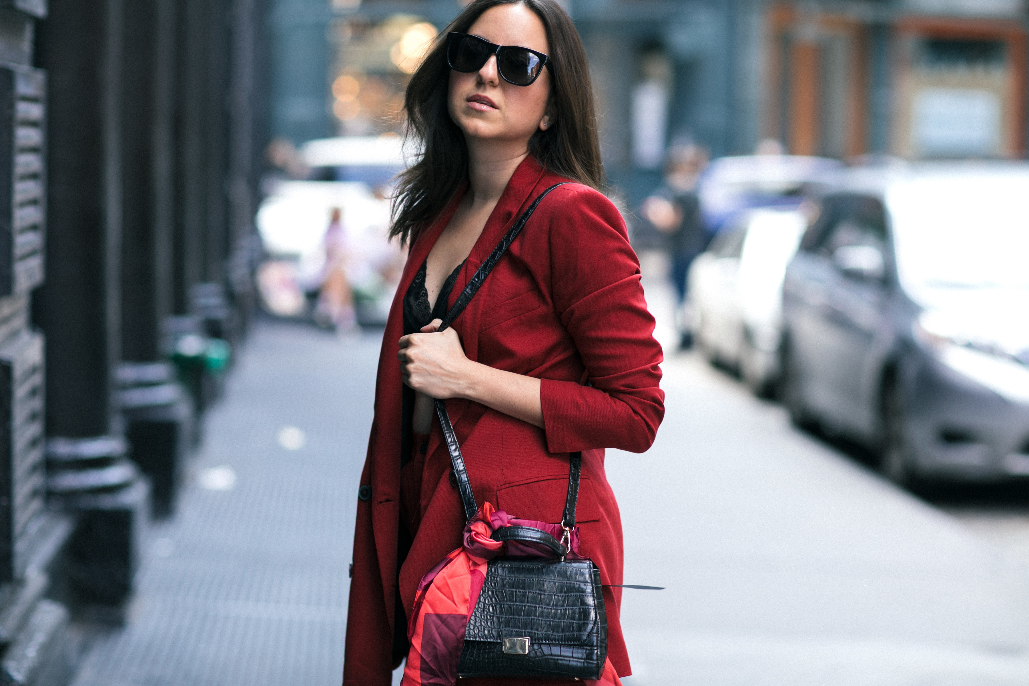 Yana Frigelis of NoMad Luxuries wearing Fall's it color of the season red for new york fashion week in a pant suit from Zara