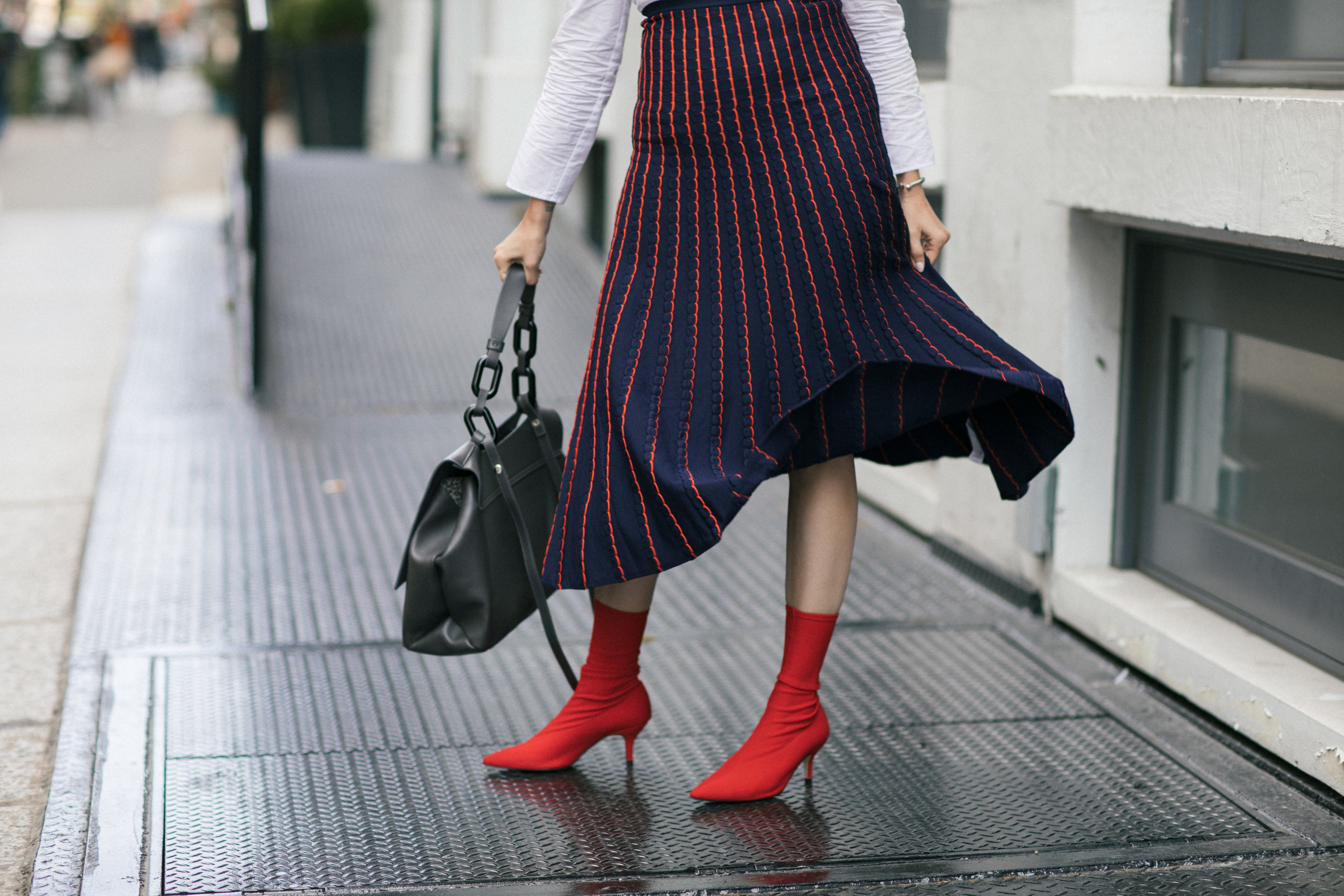 Yana Frigelis of NoMad Luxuries wearing a knit midi skirt and red boots for an fresh take on work-wear in Chicago for the Fall 