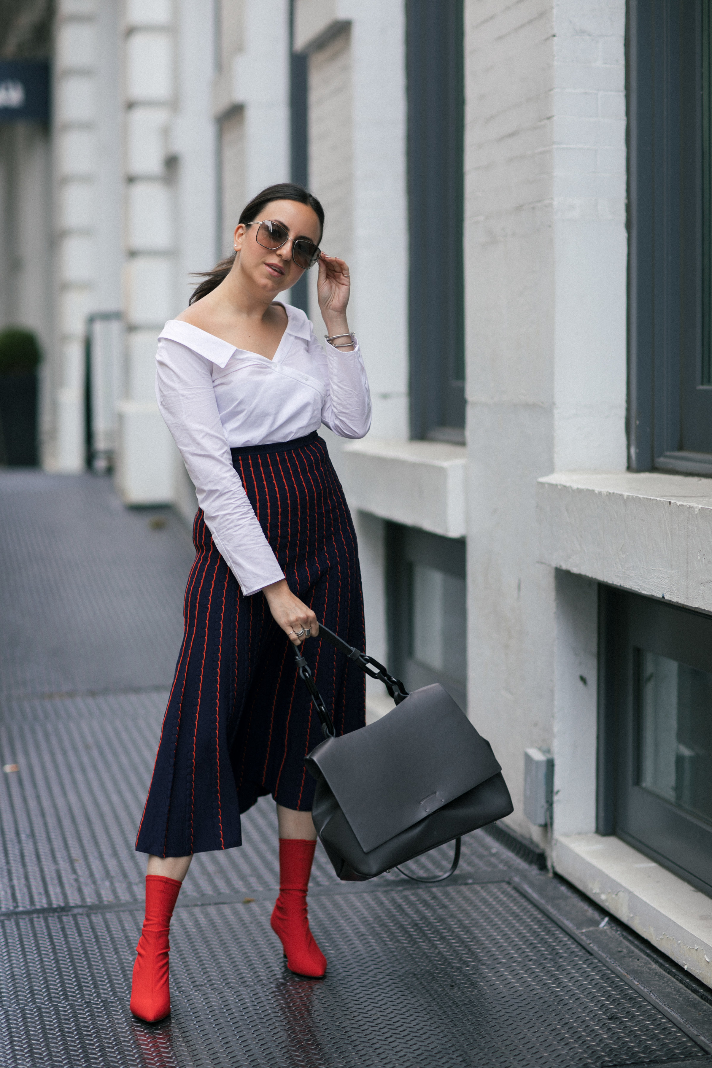 Yana Frigelis of NoMad Luxuries wearing a knit midi skirt and red boots for an fresh take on work-wear in Chicago for the Fall 