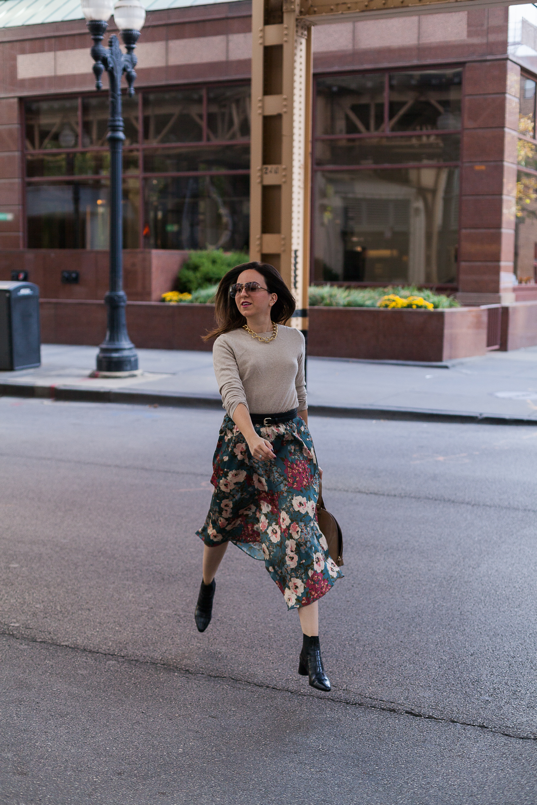 Yana Frigelis of NoMad Luxuries wearing a floral midi skirt with a neutral sweater for a Thanksgiving get together 