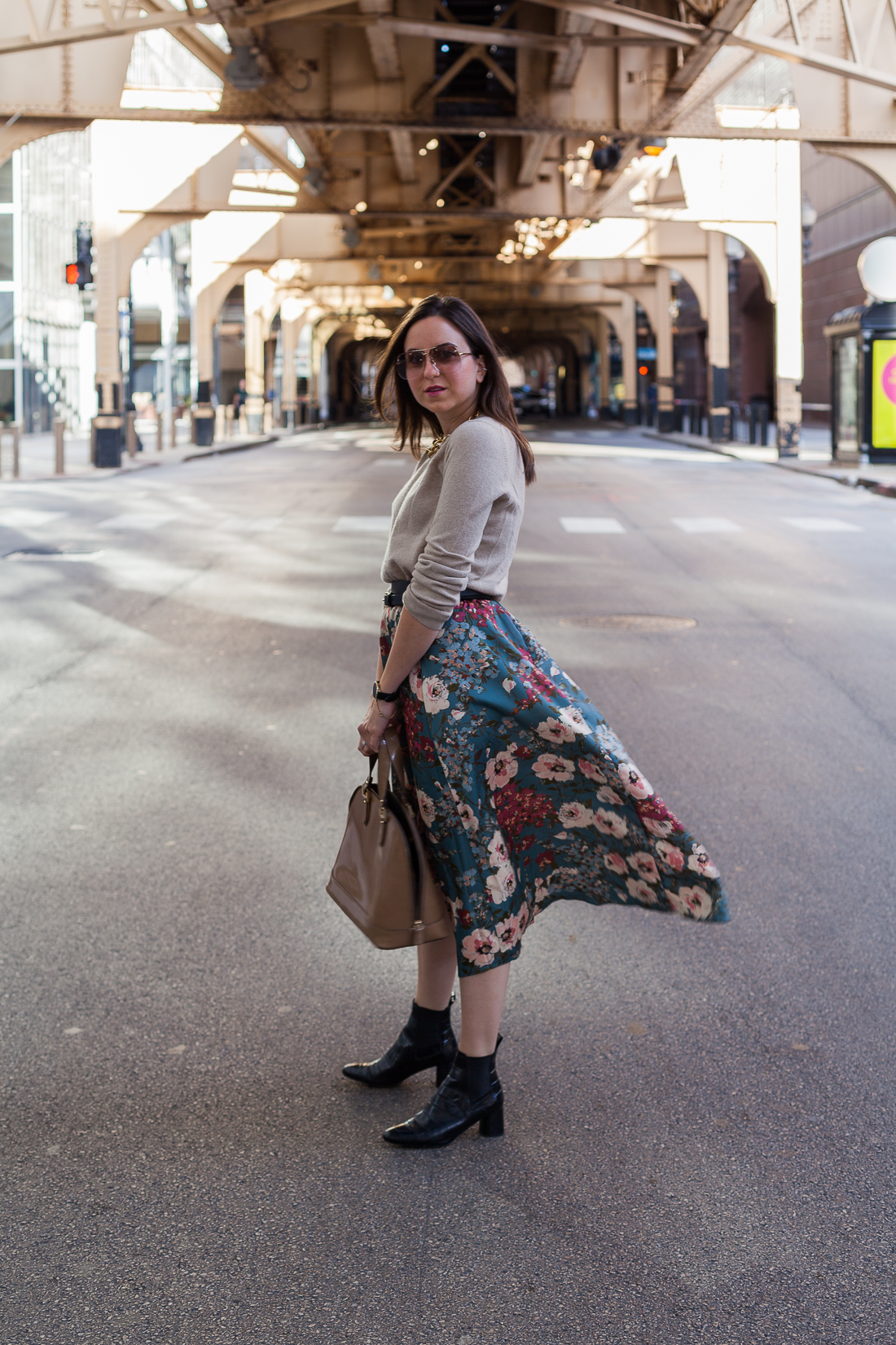 Yana Frigelis of NoMad Luxuries wearing a floral midi skirt with a neutral sweater for a Thanksgiving get together 