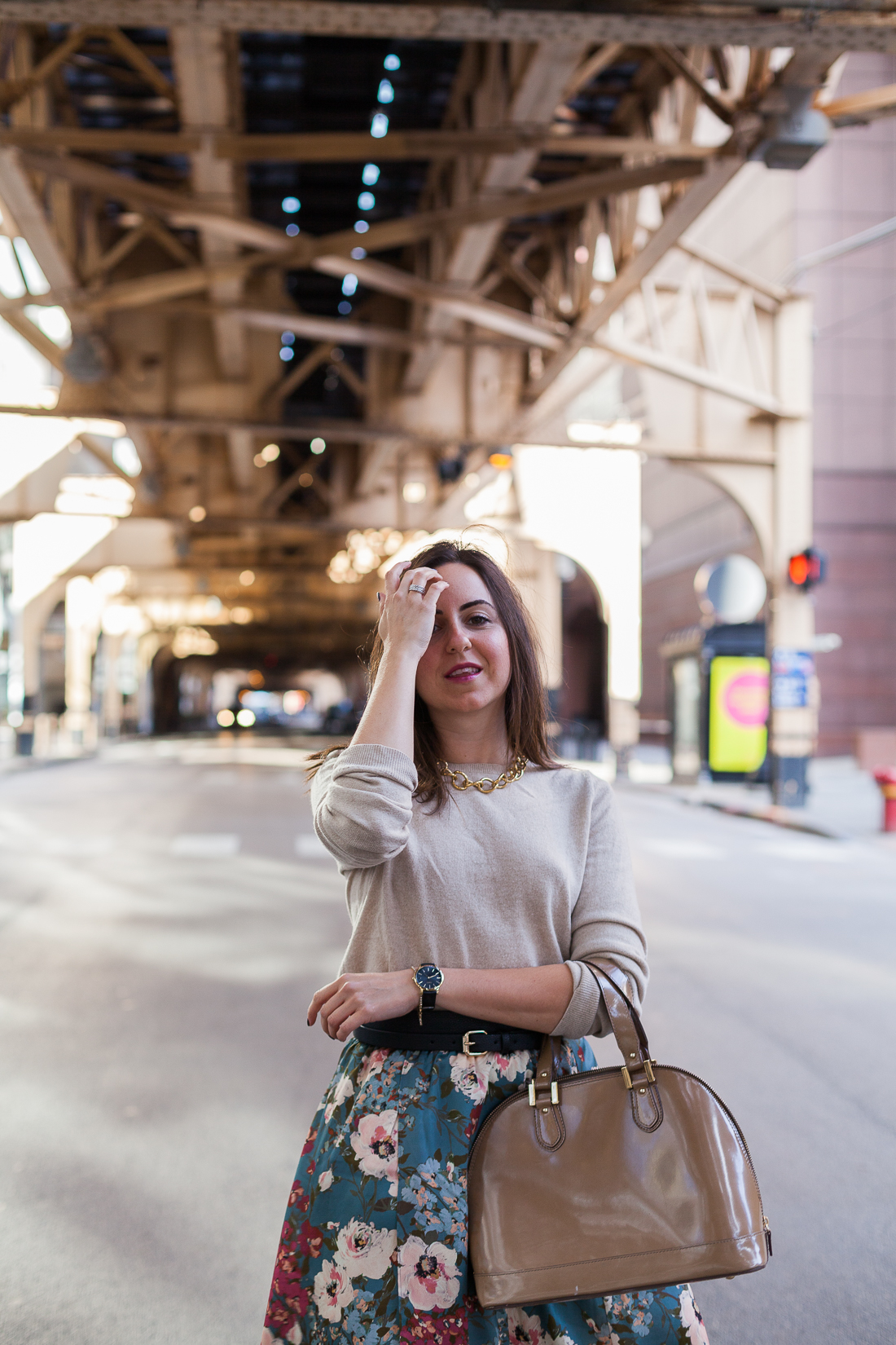 Yana Frigelis of NoMad Luxuries wearing a floral midi skirt with a neutral sweater for a Thanksgiving get together 