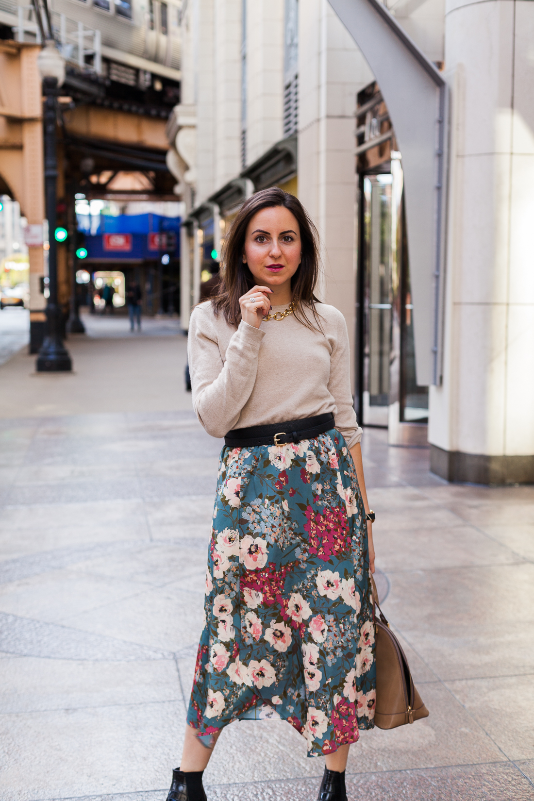 Yana Frigelis of NoMad Luxuries wearing a floral midi skirt with a neutral sweater for a Thanksgiving get together 