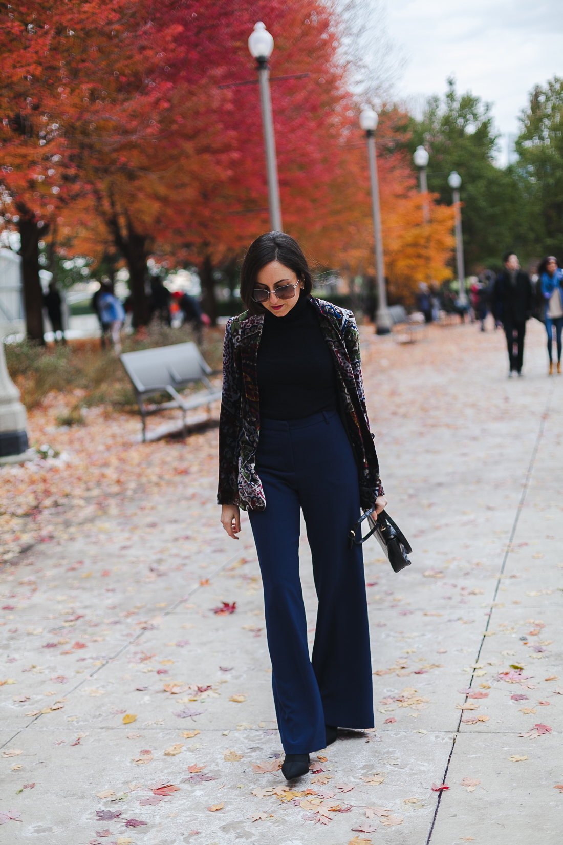 Yana Frigelis of NoMad Luxuries wearinga velvet paisley blazer, high-waisted navy pants for Thanksgiving with a 70's vibe in Chicago