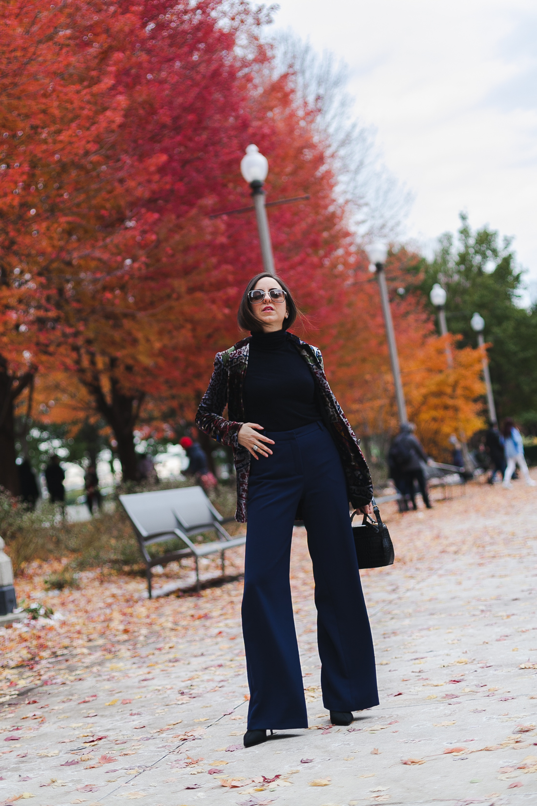 Yana Frigelis of NoMad Luxuries wearinga velvet paisley blazer, high-waisted navy pants for Thanksgiving with a 70's vibe in Chicago