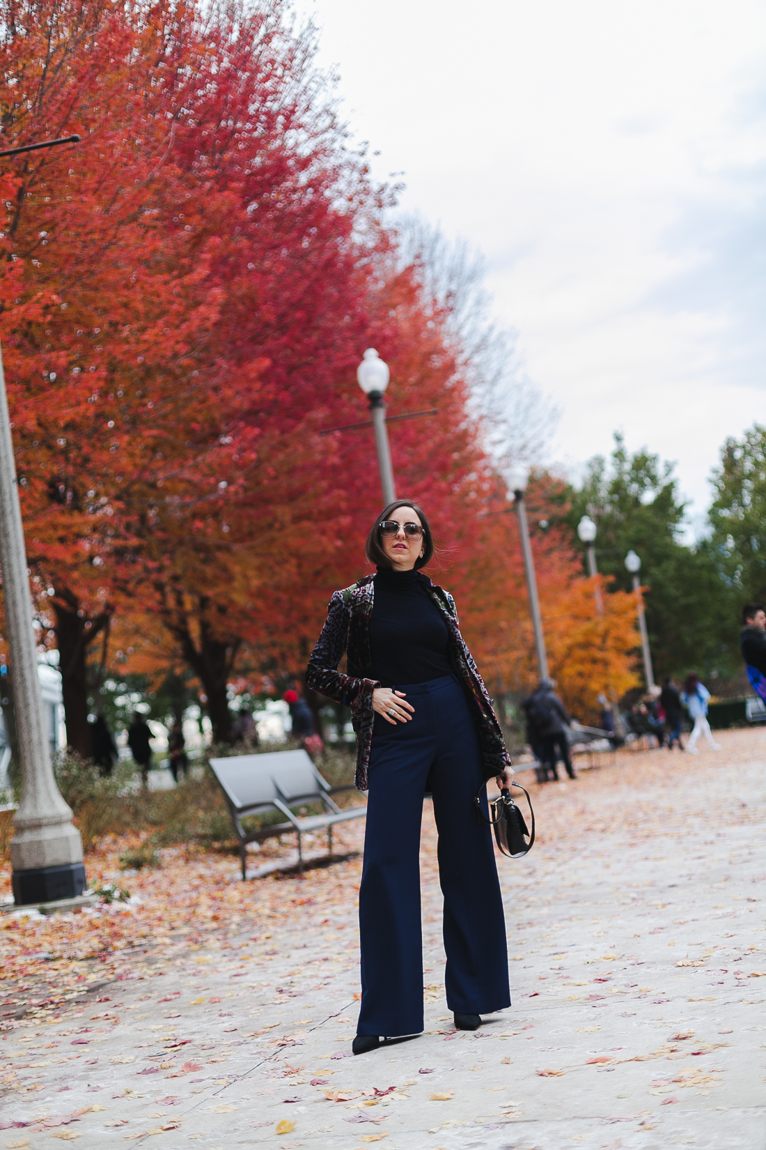 Yana Frigelis of NoMad Luxuries wearinga velvet paisley blazer, high-waisted navy pants for Thanksgiving with a 70's vibe in Chicago