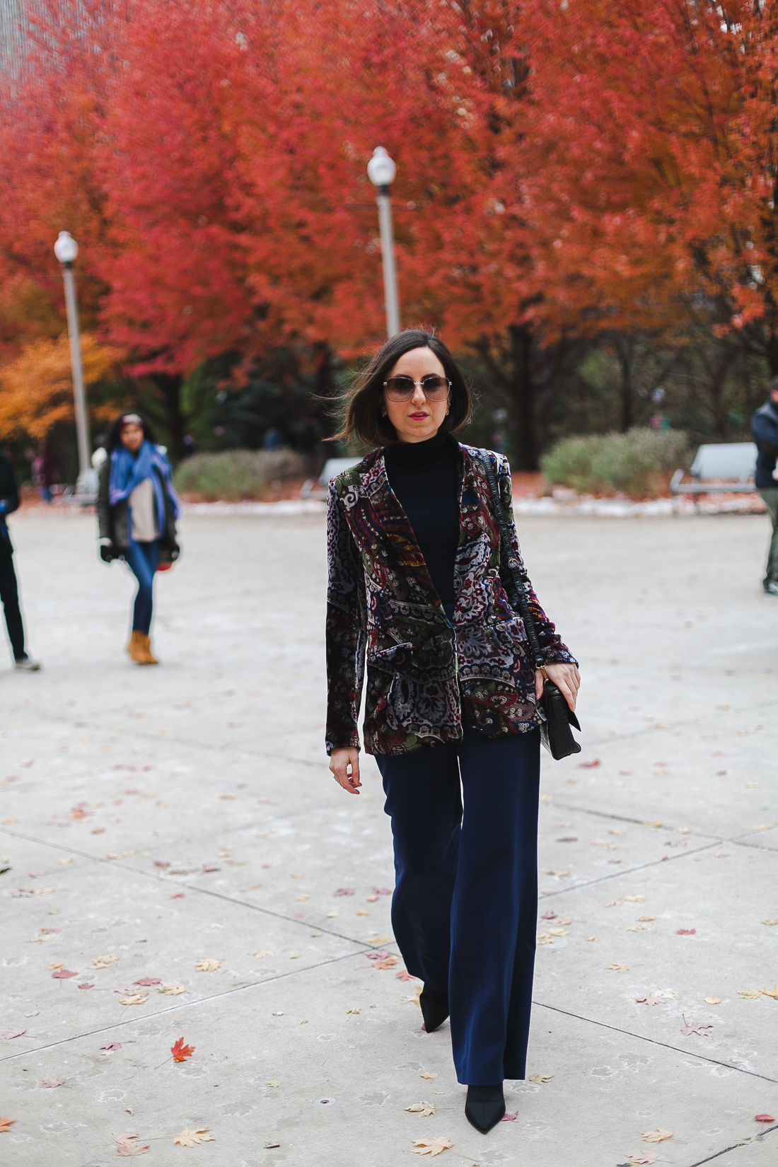 Yana Frigelis of NoMad Luxuries wearinga velvet paisley blazer, high-waisted navy pants for Thanksgiving with a 70's vibe in Chicago