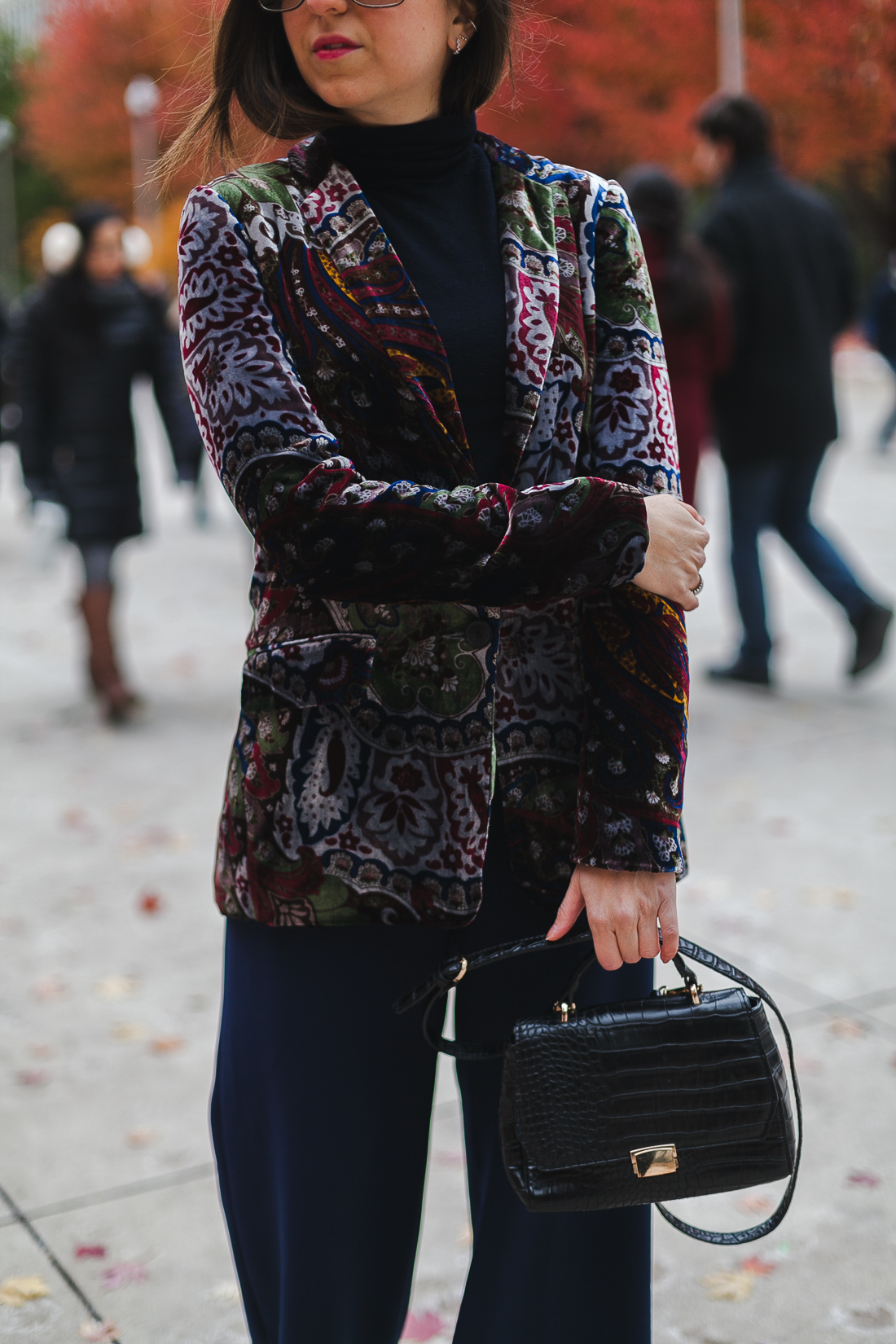 Yana Frigelis of NoMad Luxuries wearinga velvet paisley blazer, high-waisted navy pants for Thanksgiving with a 70's vibe in Chicago