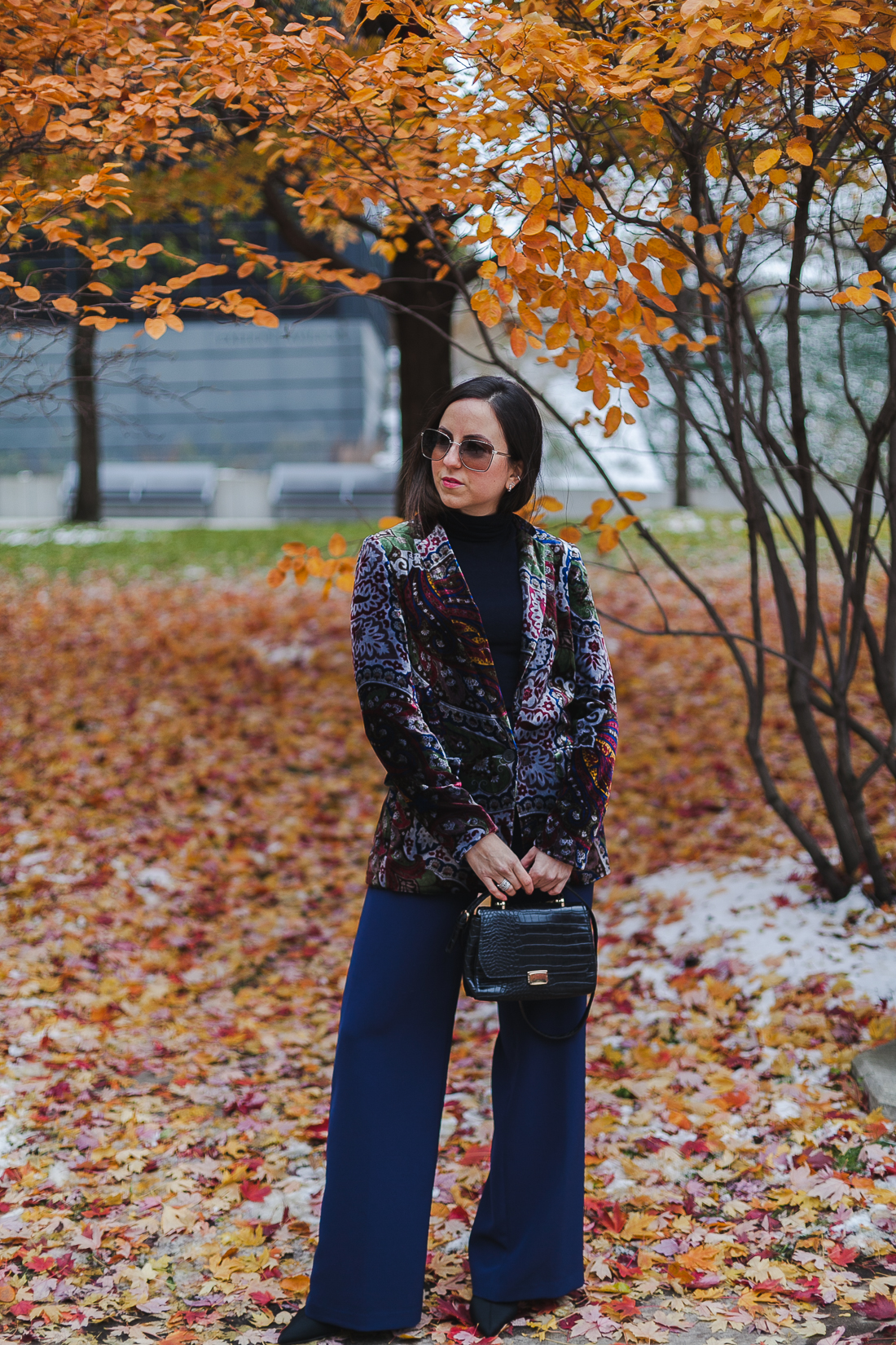 Yana Frigelis of NoMad Luxuries wearinga velvet paisley blazer, high-waisted navy pants for Thanksgiving with a 70's vibe in Chicago