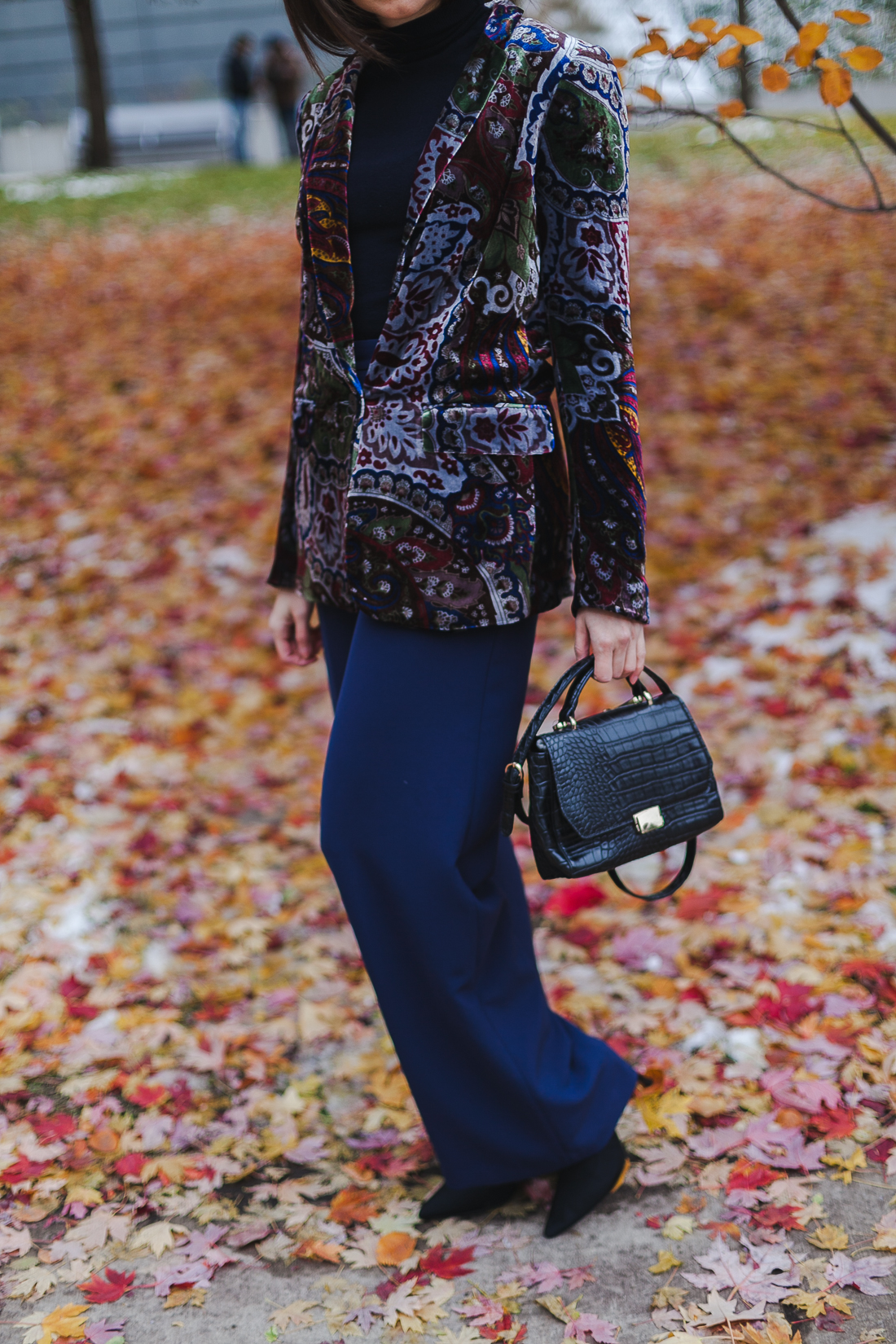 Yana Frigelis of NoMad Luxuries wearinga velvet paisley blazer, high-waisted navy pants for Thanksgiving with a 70's vibe in Chicago
