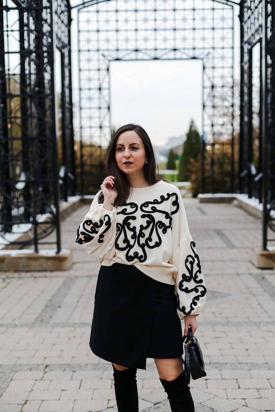 Yana Frigelis of NoMad Luxuries wearing an embroidered sweatshirt from zara and over the knee boots for a simple yet statement making outfit 