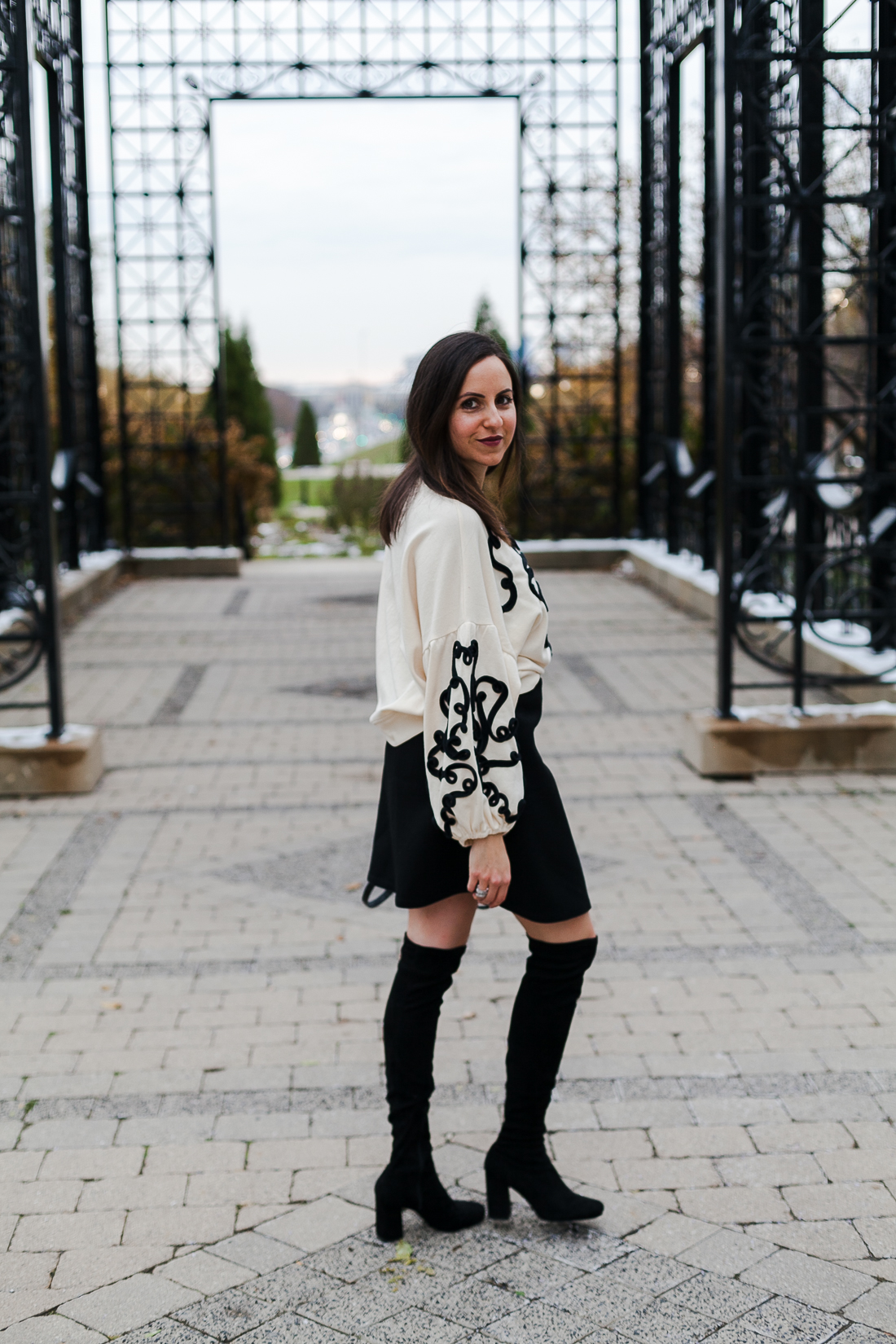 Yana Frigelis of NoMad Luxuries wearing an embroidered sweatshirt from zara and over the knee boots for a simple yet statement making outfit 