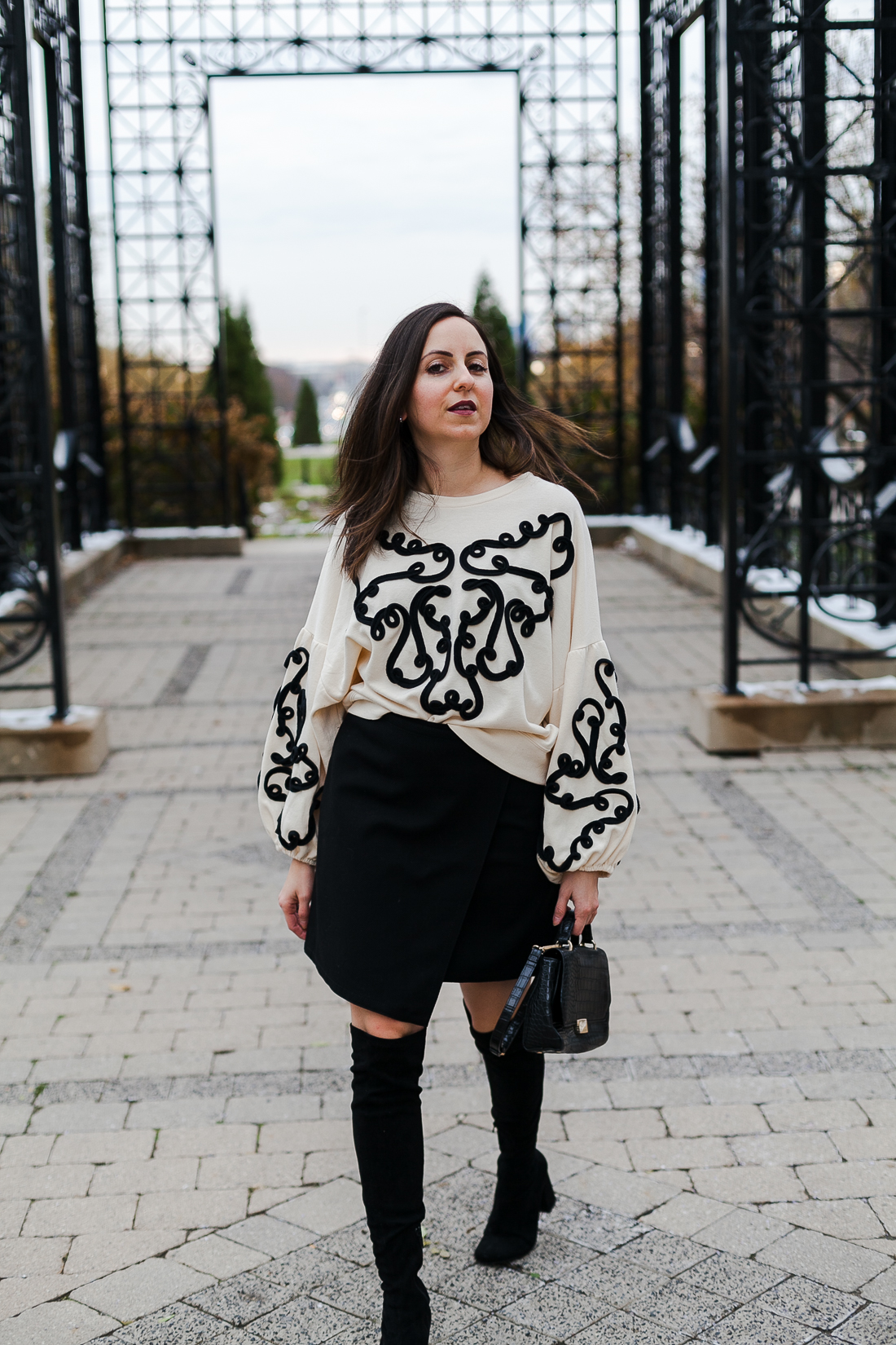 Yana Frigelis of NoMad Luxuries wearing an embroidered sweatshirt from zara and over the knee boots for a simple yet statement making outfit 