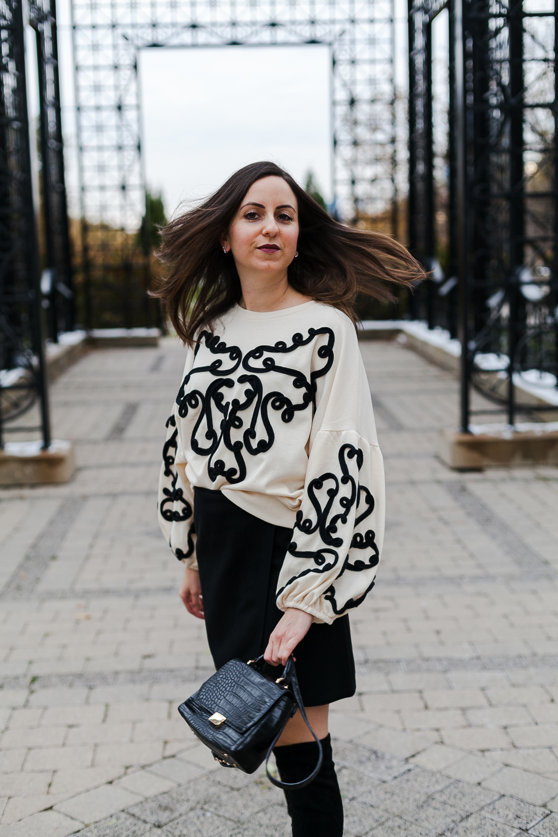 Yana Frigelis of NoMad Luxuries wearing an embroidered sweatshirt from zara and over the knee boots for a simple yet statement making outfit 