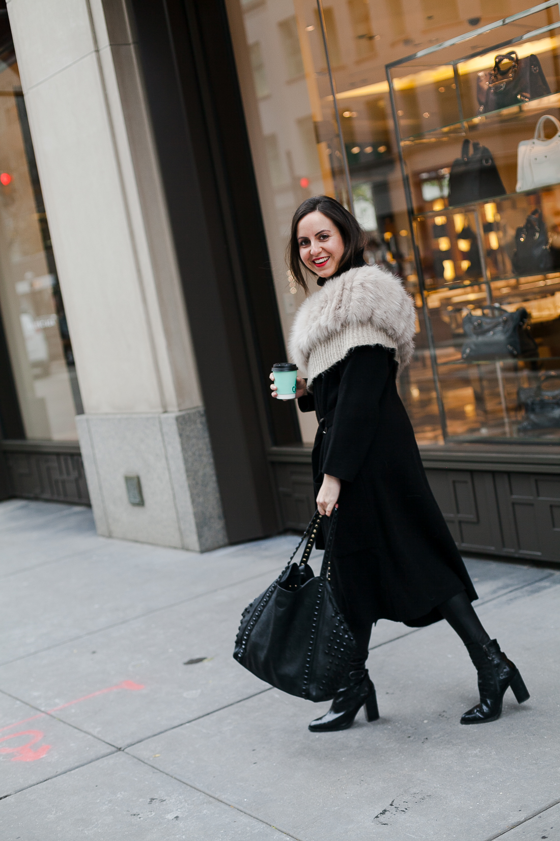 Yana Frigelis of NoMad Luxuries wearing an all black french-inspired look with a fur stole from mango