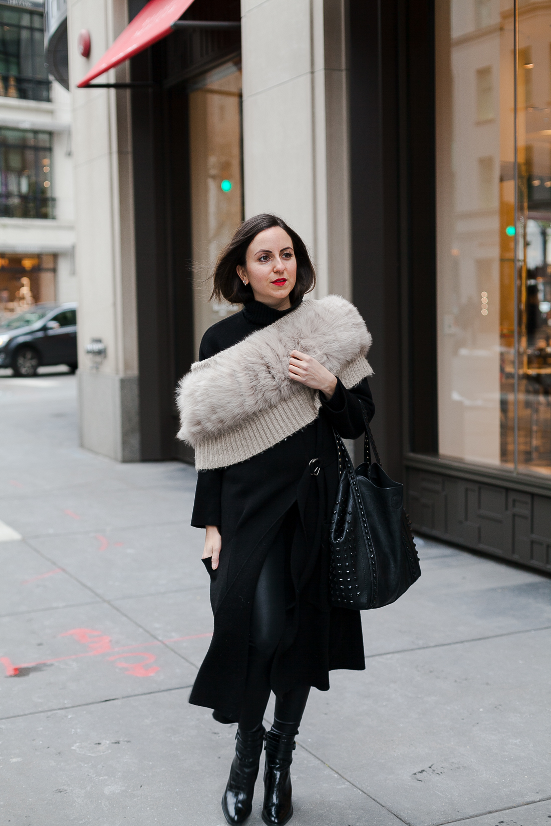 Yana Frigelis of NoMad Luxuries wearing an all black french-inspired look with a fur stole from mango