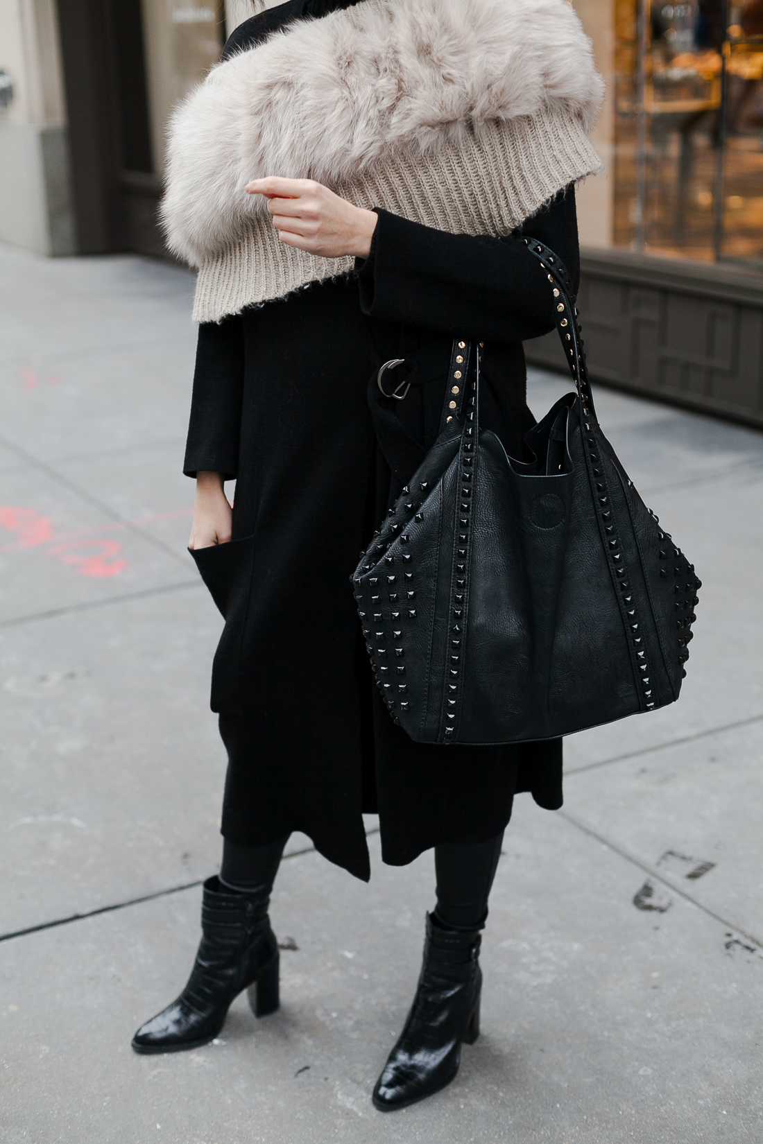 Yana Frigelis of NoMad Luxuries wearing an all black french-inspired look with a fur stole from mango