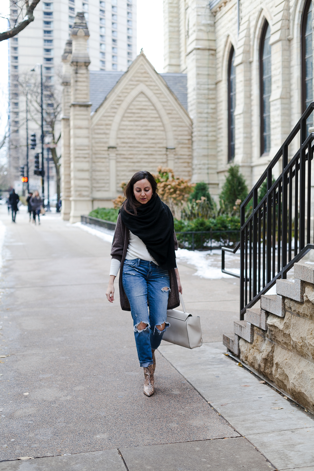 Yana Frigelis of NoMad Luxuries wearing a neutral look with ripped jeans and snake skin booties for Fall in Chicago