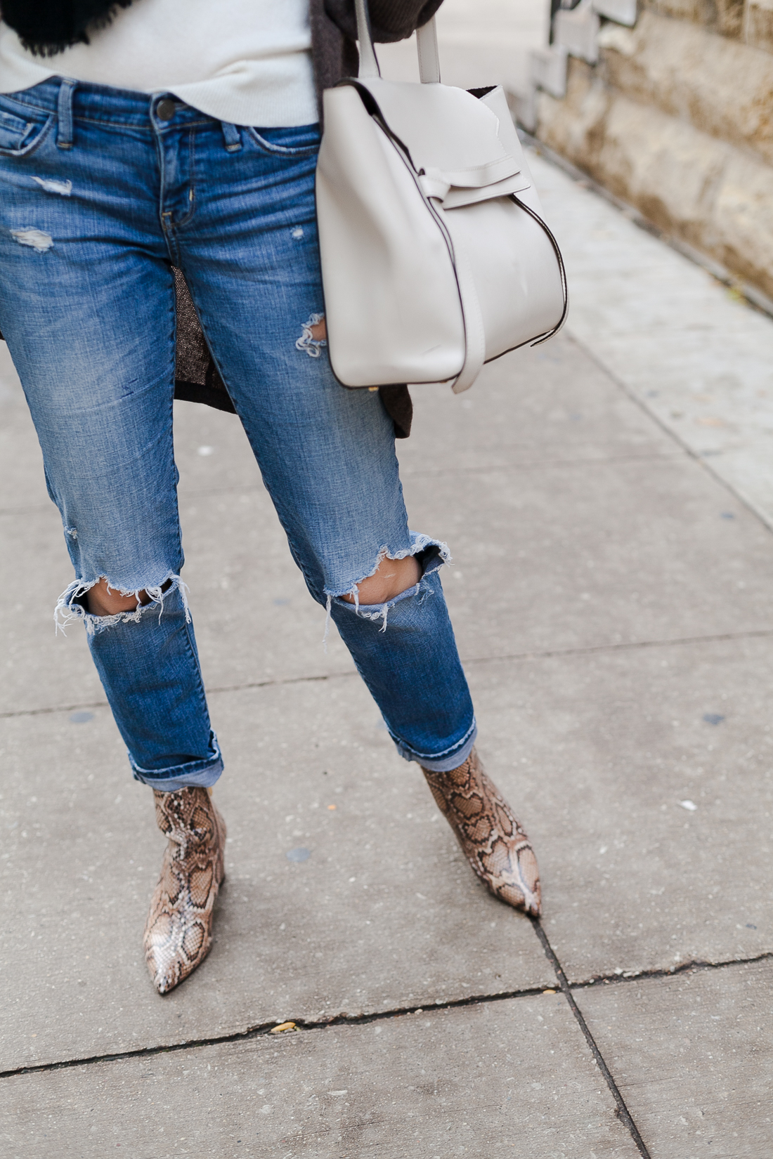 Yana Frigelis of NoMad Luxuries wearing a neutral look with ripped jeans and snake skin booties for Fall in Chicago