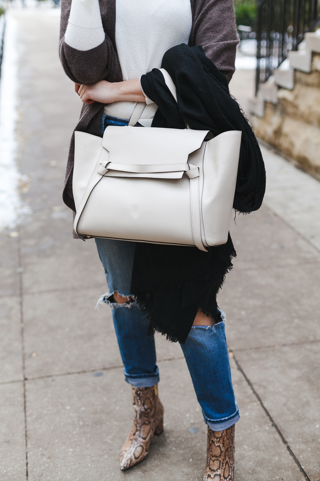 Yana Frigelis of NoMad Luxuries wearing a neutral look with ripped jeans and snake skin booties for Fall in Chicago