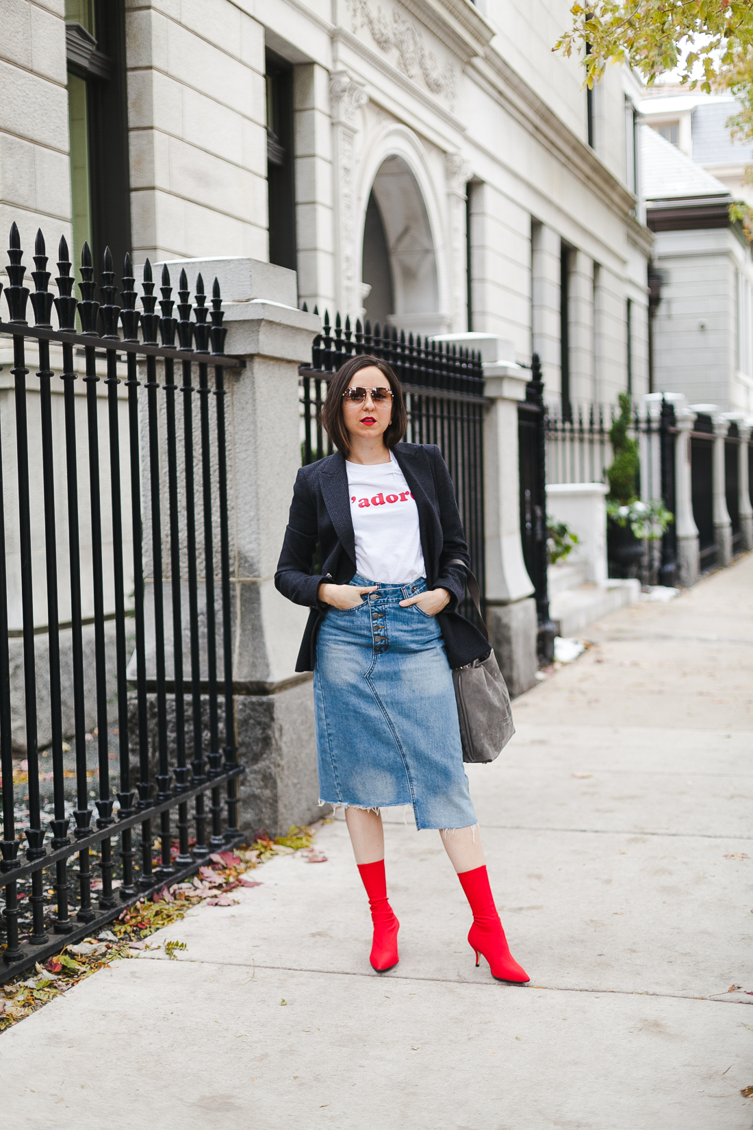 Yana Frigelis of NoMad Luxuries wearing a graphic tee under a blazer with red sock boots and a jean retro skirt for Fall