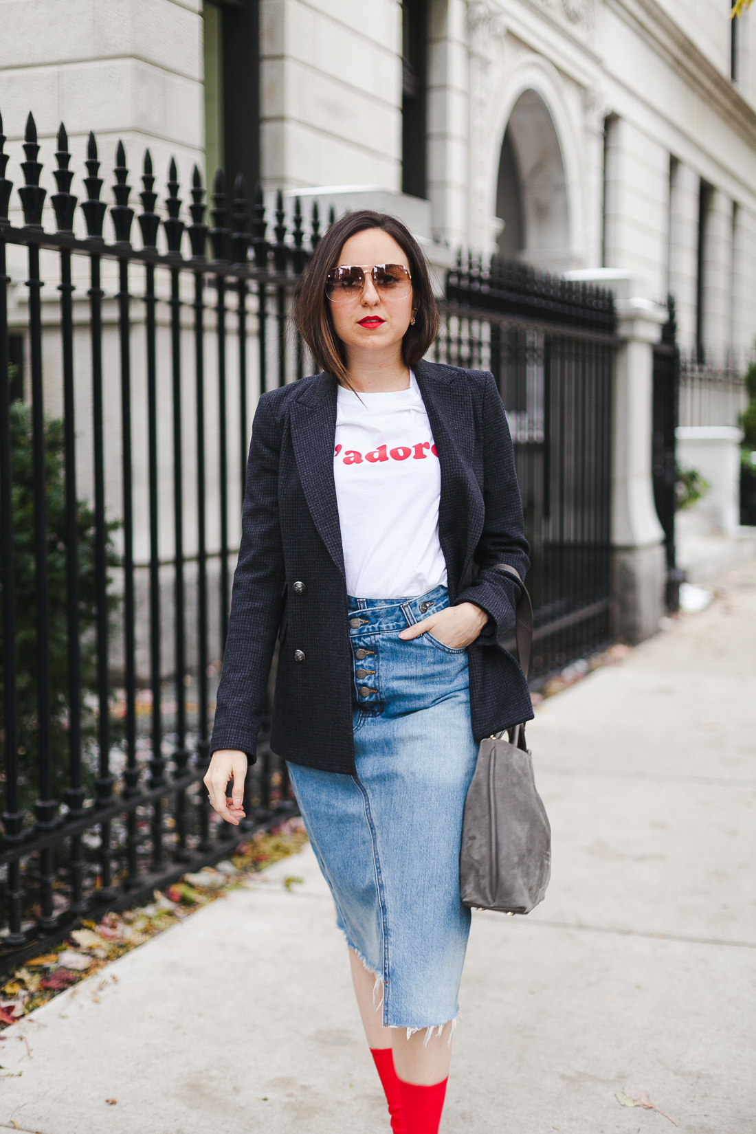 Yana Frigelis of NoMad Luxuries wearing a graphic tee under a blazer with red sock boots and a jean retro skirt for Fall