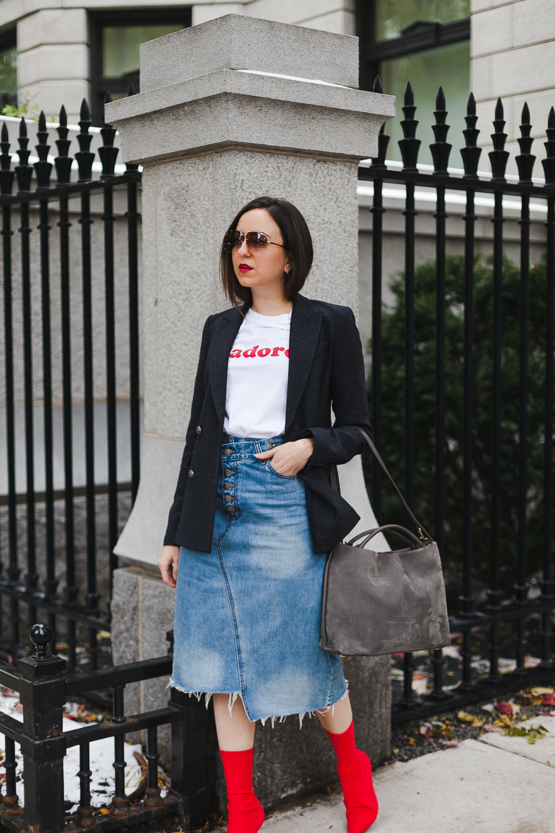 Yana Frigelis of NoMad Luxuries wearing a graphic tee under a blazer with red sock boots and a jean retro skirt for Fall