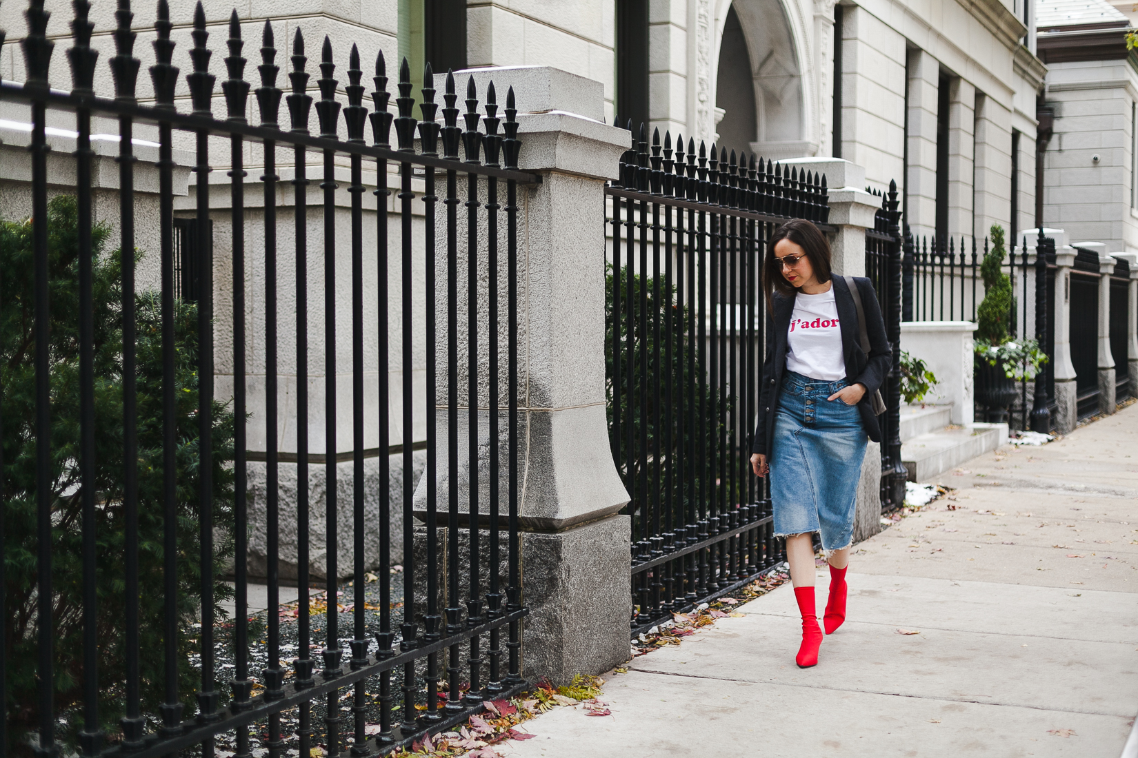 Yana Frigelis of NoMad Luxuries wearing a graphic tee under a blazer with red sock boots and a jean retro skirt for Fall